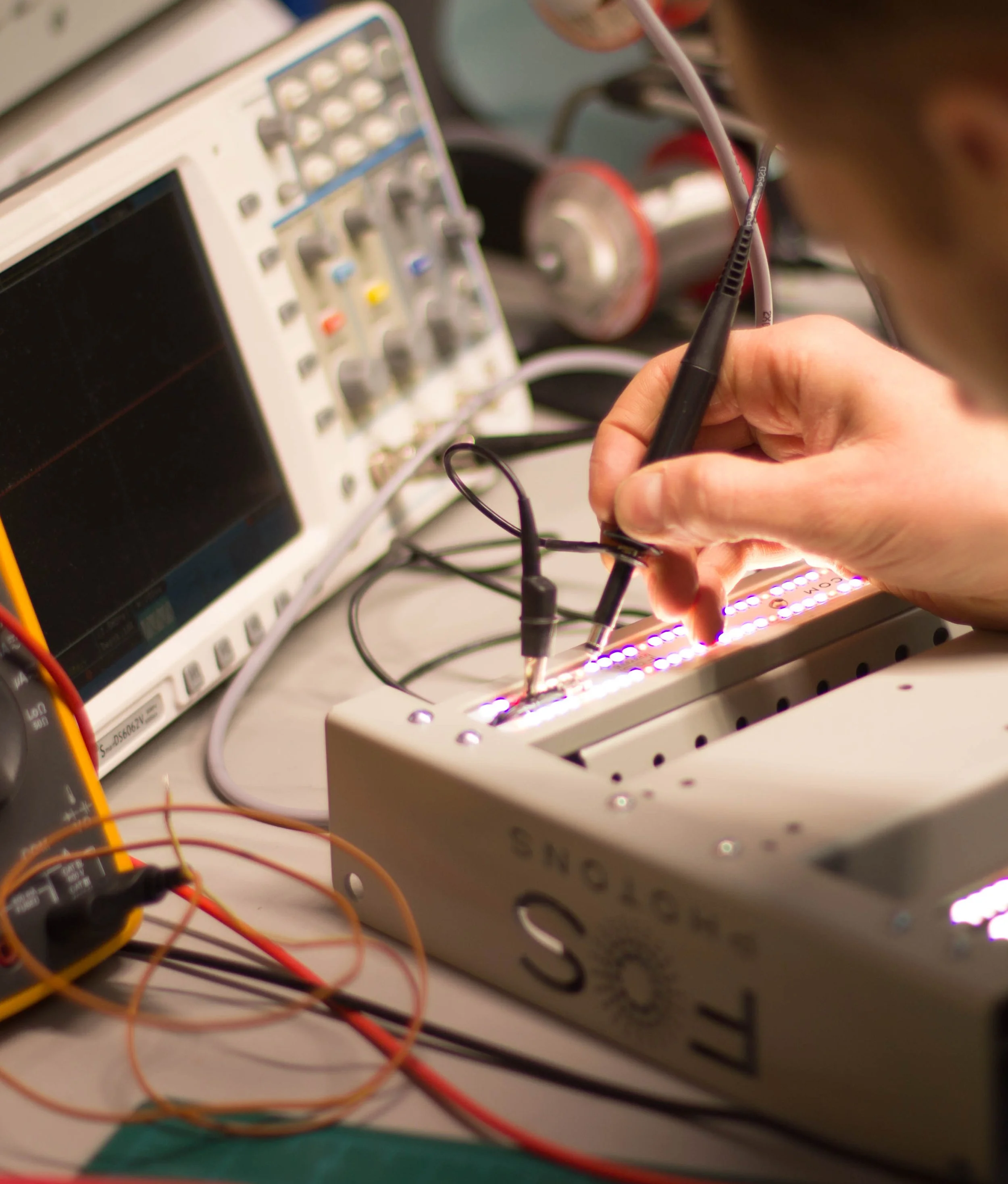 LED lighting prototype undergoing electrical testing with oscilloscope during development phase.