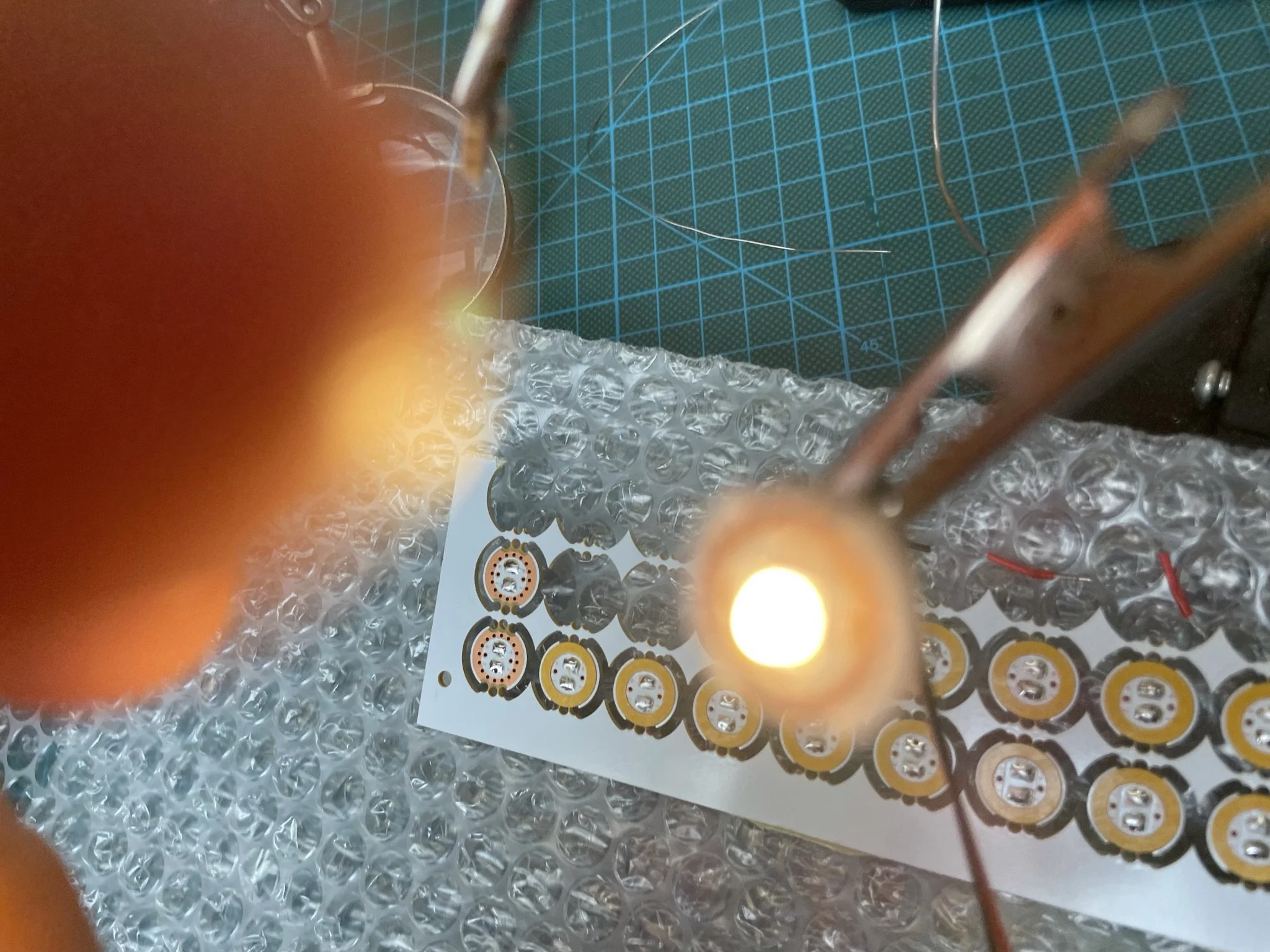 LED module being removed from circuit board for electrical testing during prototype development.