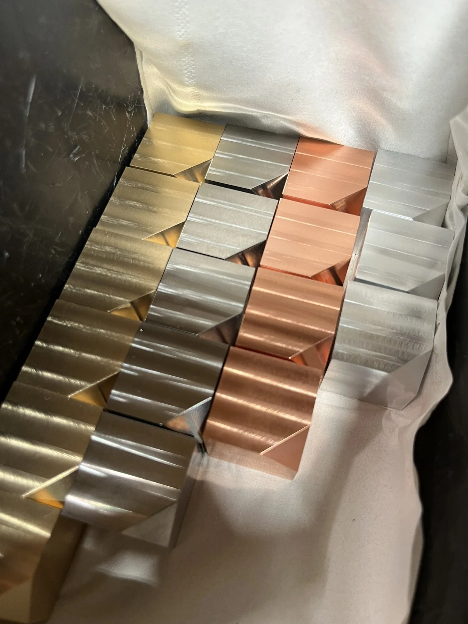 Machined cubes in copper, brass, and aluminium showing clean milled finishes.