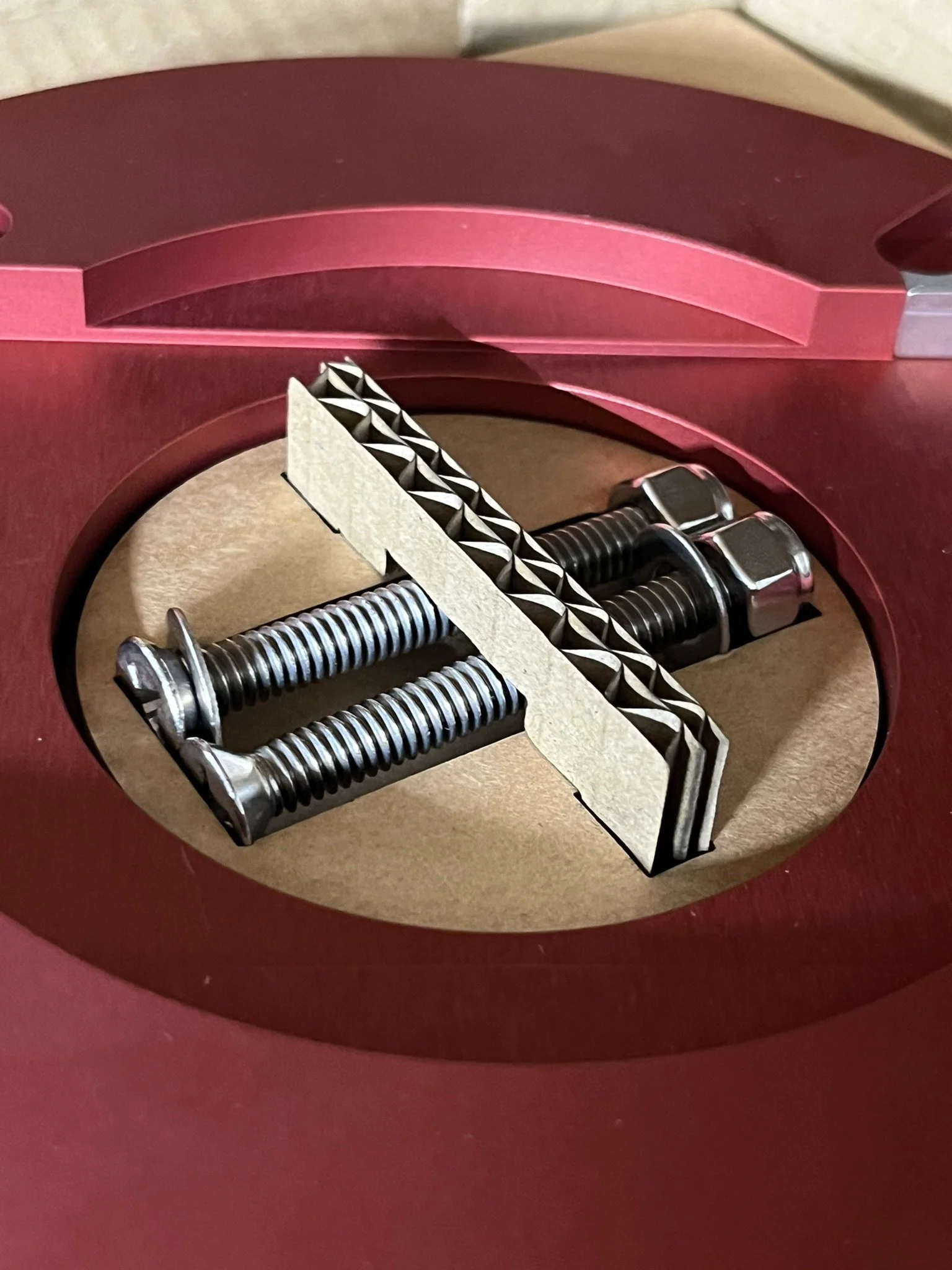 Custom-cut cardboard packaging insert holding bolts securely for shipping.