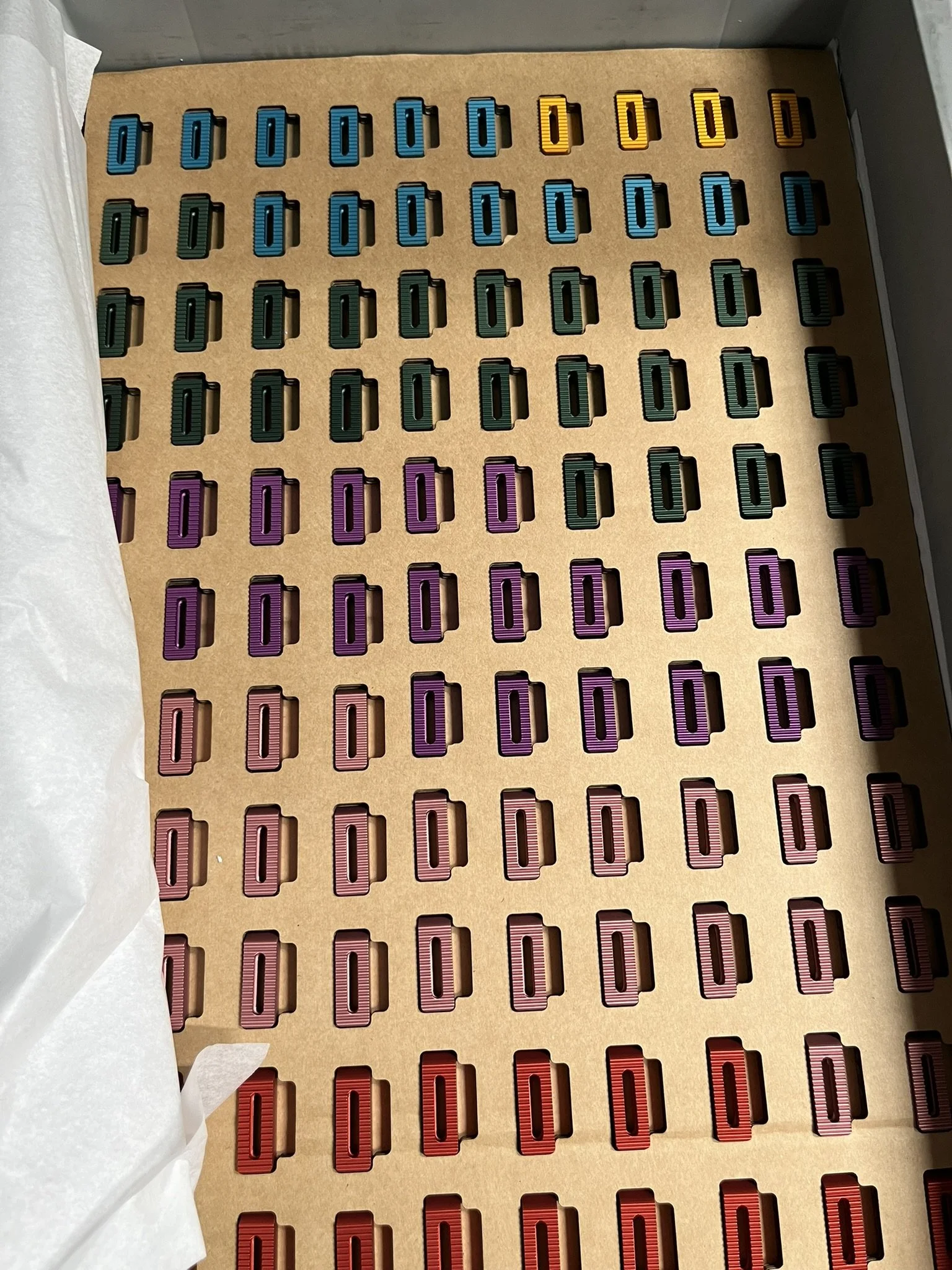 Anodised machined parts arranged in custom trays after finishing