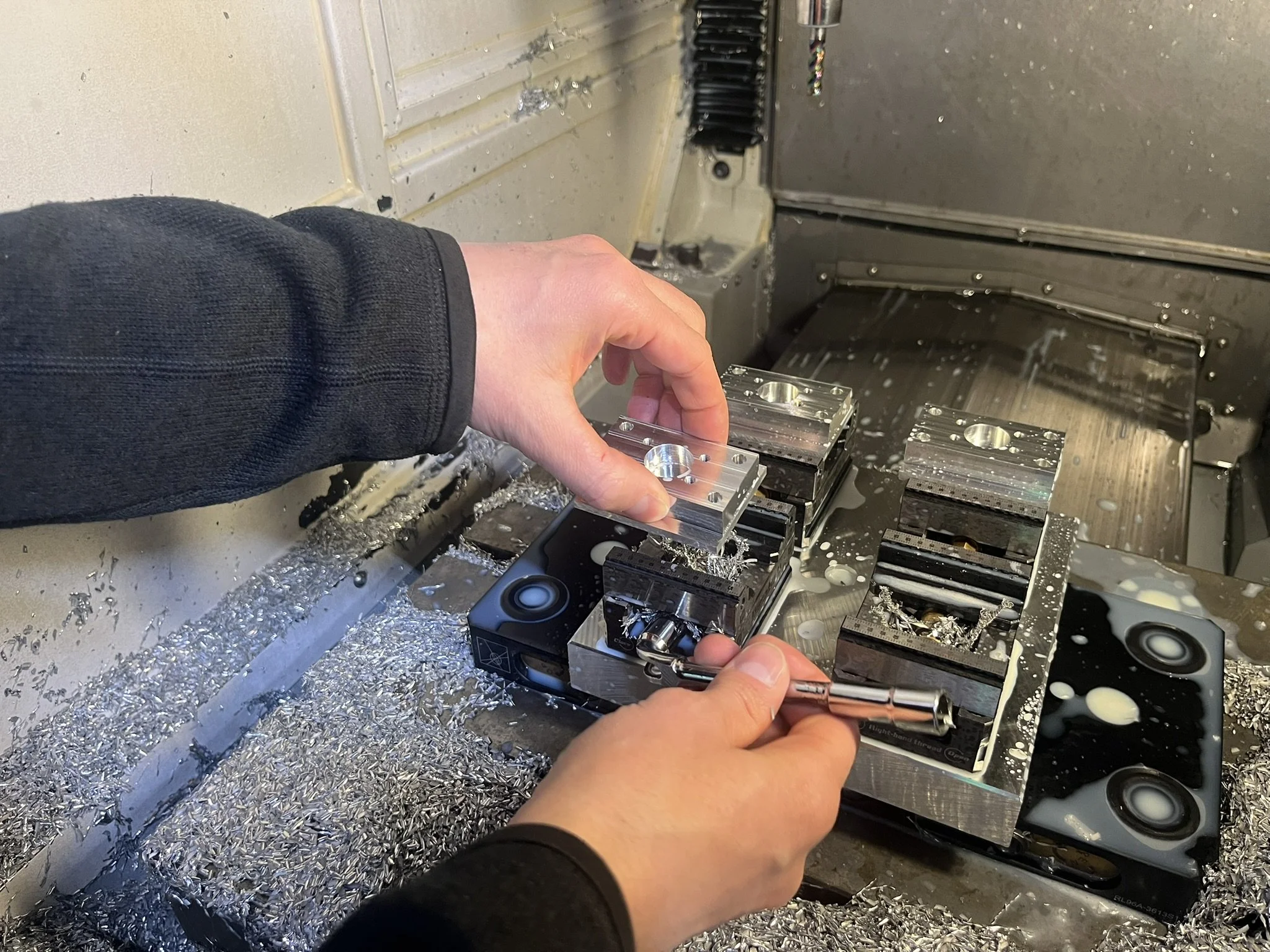 Aluminium parts being removed from CNC milling machine at Karpas Engineering workshop in Hertfordshire