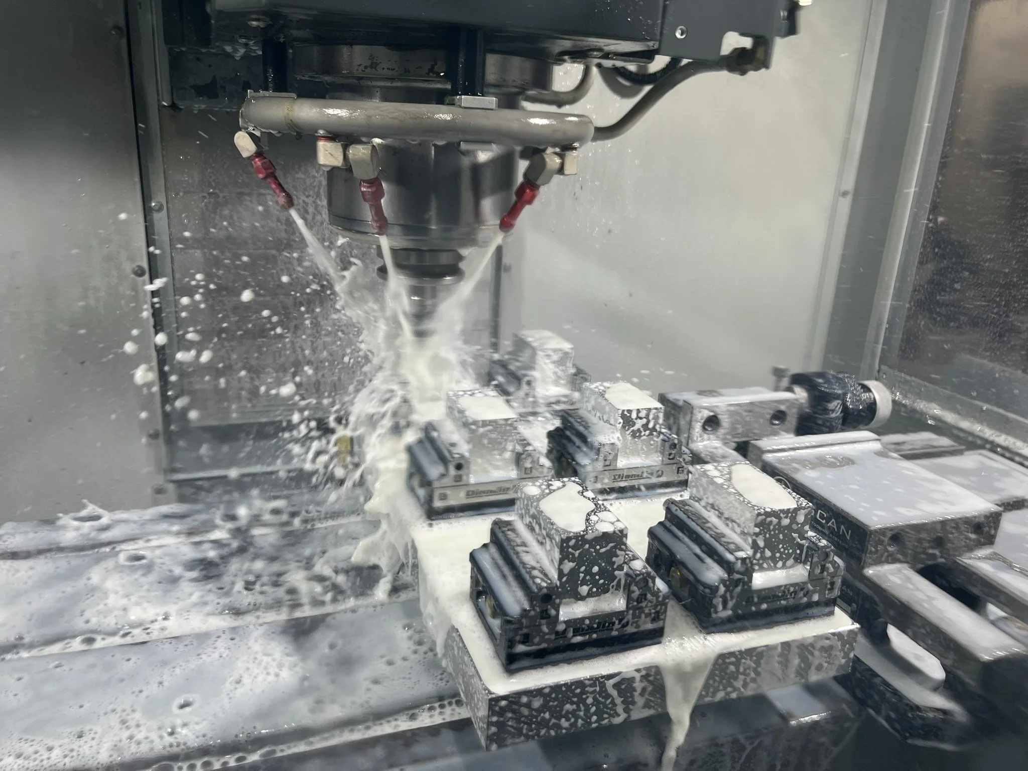CNC milling multiple aluminium parts in vices during a machining cycle.