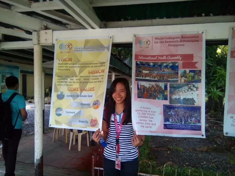 Shelaine posing with the posters used to promote CARP