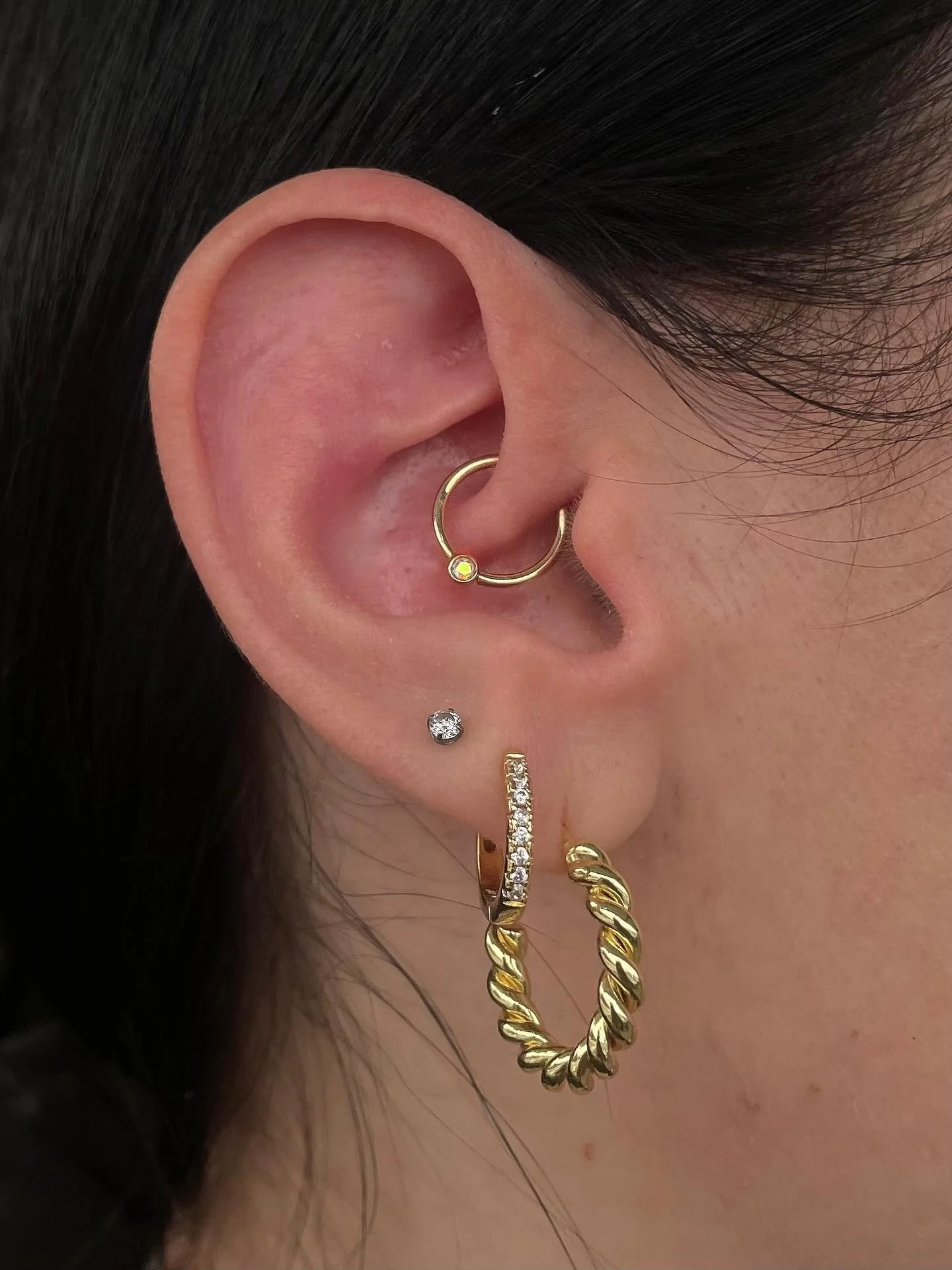 A fresh daith piercing from @thirdbevel using a solid yellow gold ring with genuine mercury mist topaz - you can find Trevor here every Monday + Tuesday, book now or walk in! ✨