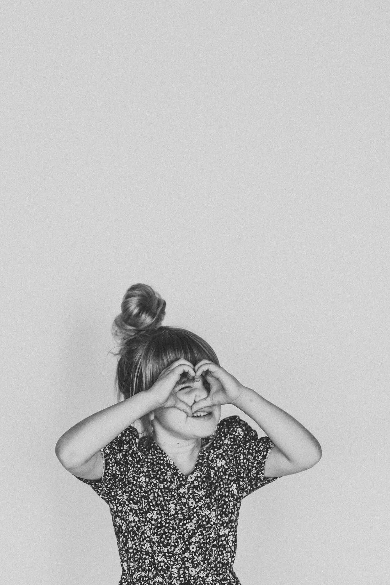 Better Than School Portraits Black and White image of child making heart with hands