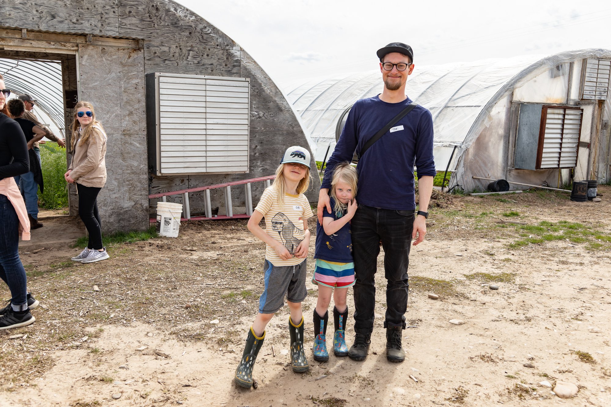 Father and children pose in front of the greenhouses.
