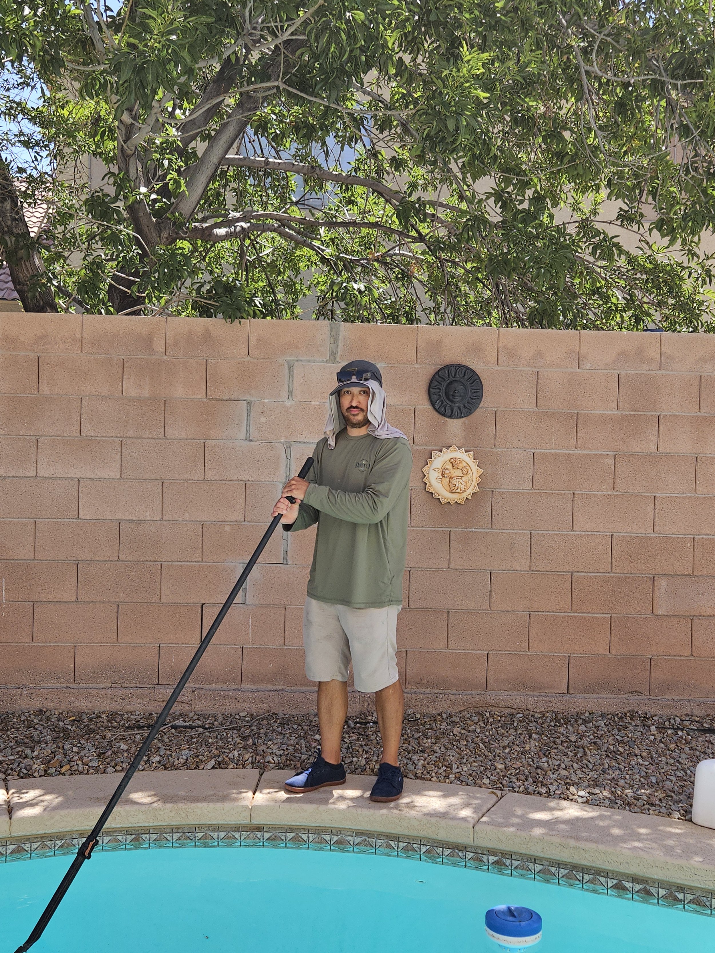 man vacuuming pool