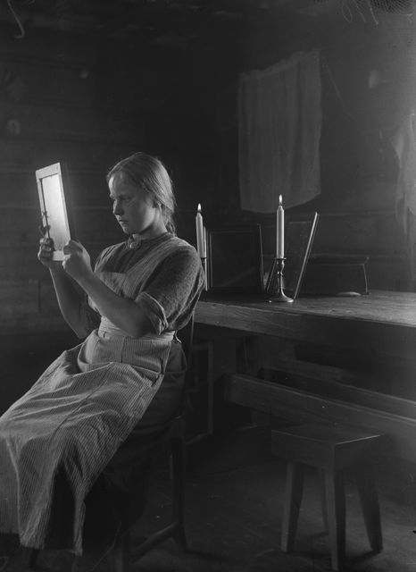 Peilillä ennustaminen. Samaa tekniikkaa on käytetty uuden vuoden yönä, kuten tässä kuvassa ajalta 1907-23. Kuvaaja Samuli Paulaharju. Kuva: Museoviraston kuvakokoelmat, Kansatieteen kuvakokoelma.