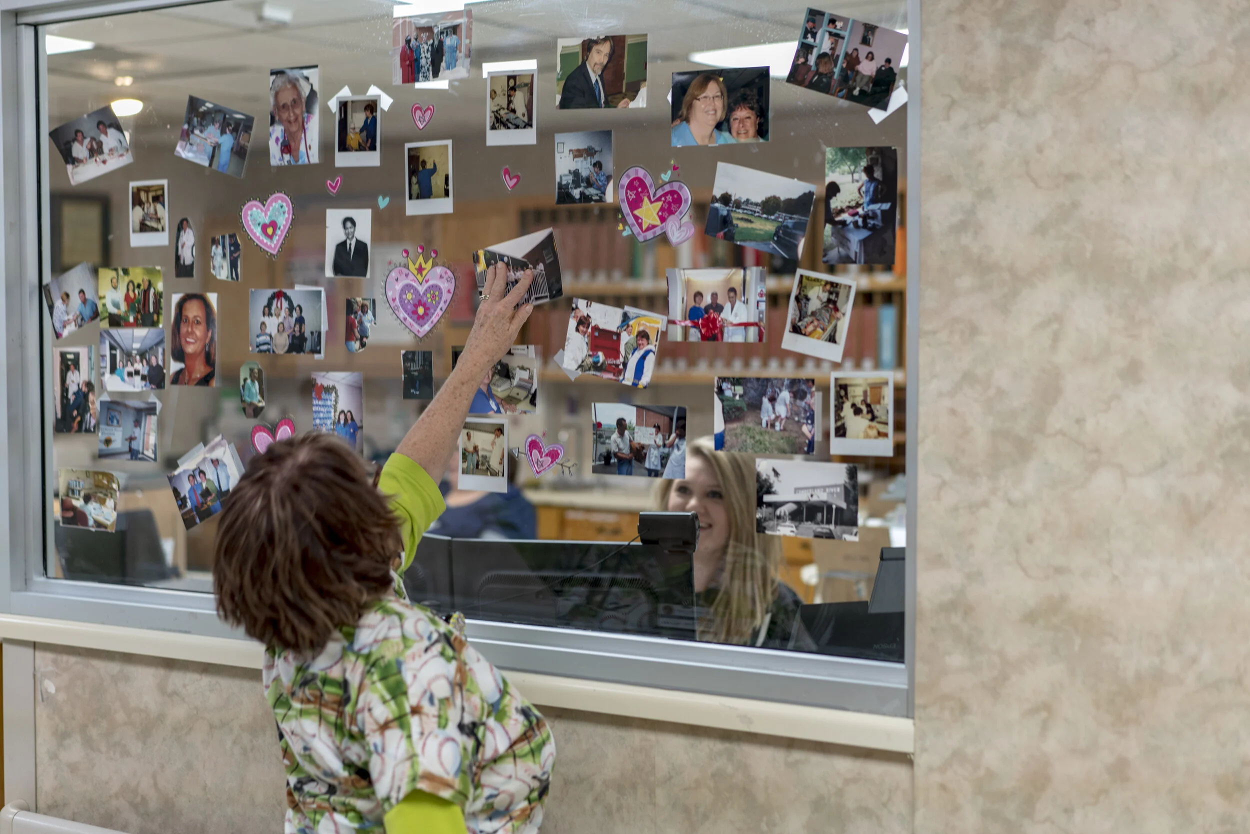 Nurse removes photos of staff memories from the administrative office in the final hours of the operation of Cumberland River Hospital.