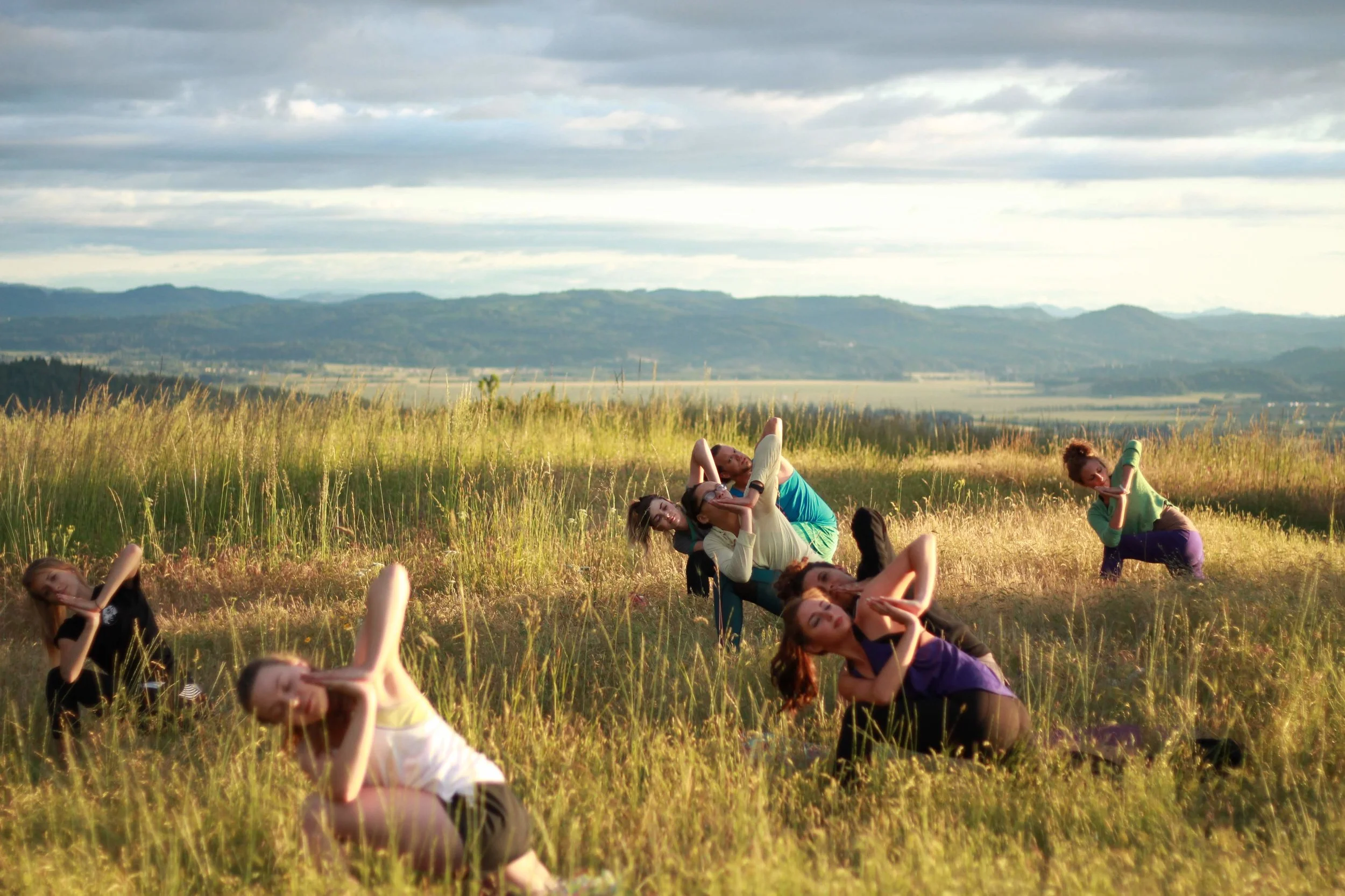 A group of yogis practicing namaskar parsvakonasana at the top of Mt. Pisgah. Photo by @lanceswithwolves