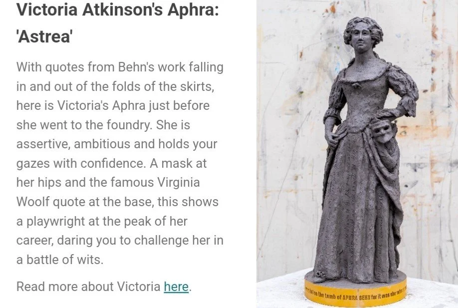 Statue of Victoria Atkinson's Aphra, a woman in a long dress with a mask at her hips, standing on a yellow base with text.