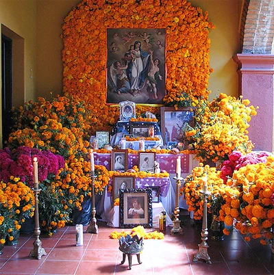 Example of a Day of the Dead altar with marigold flowers and pictures of deceased loved ones