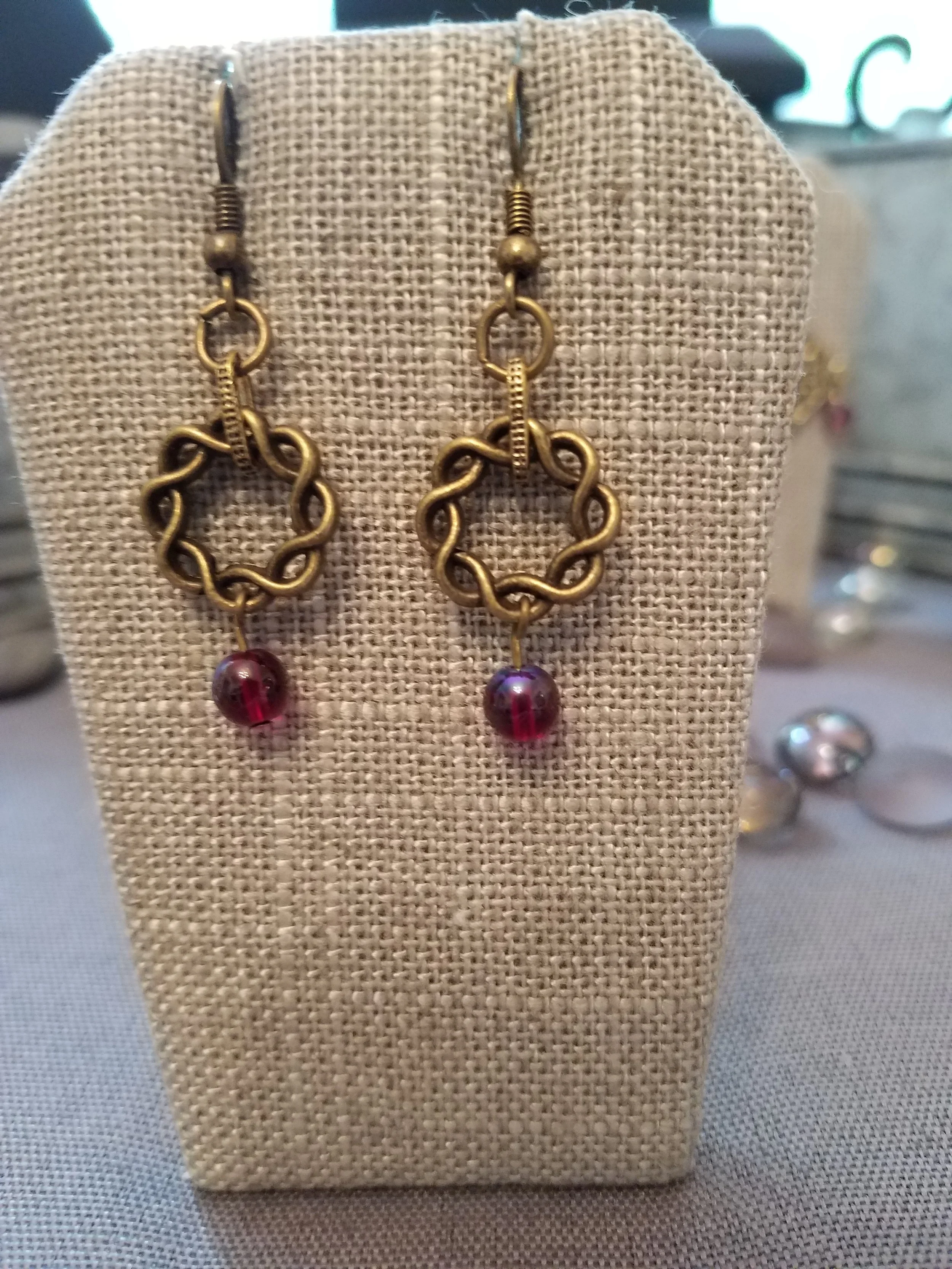 Antique gold braided wreath with garnet color glass bead