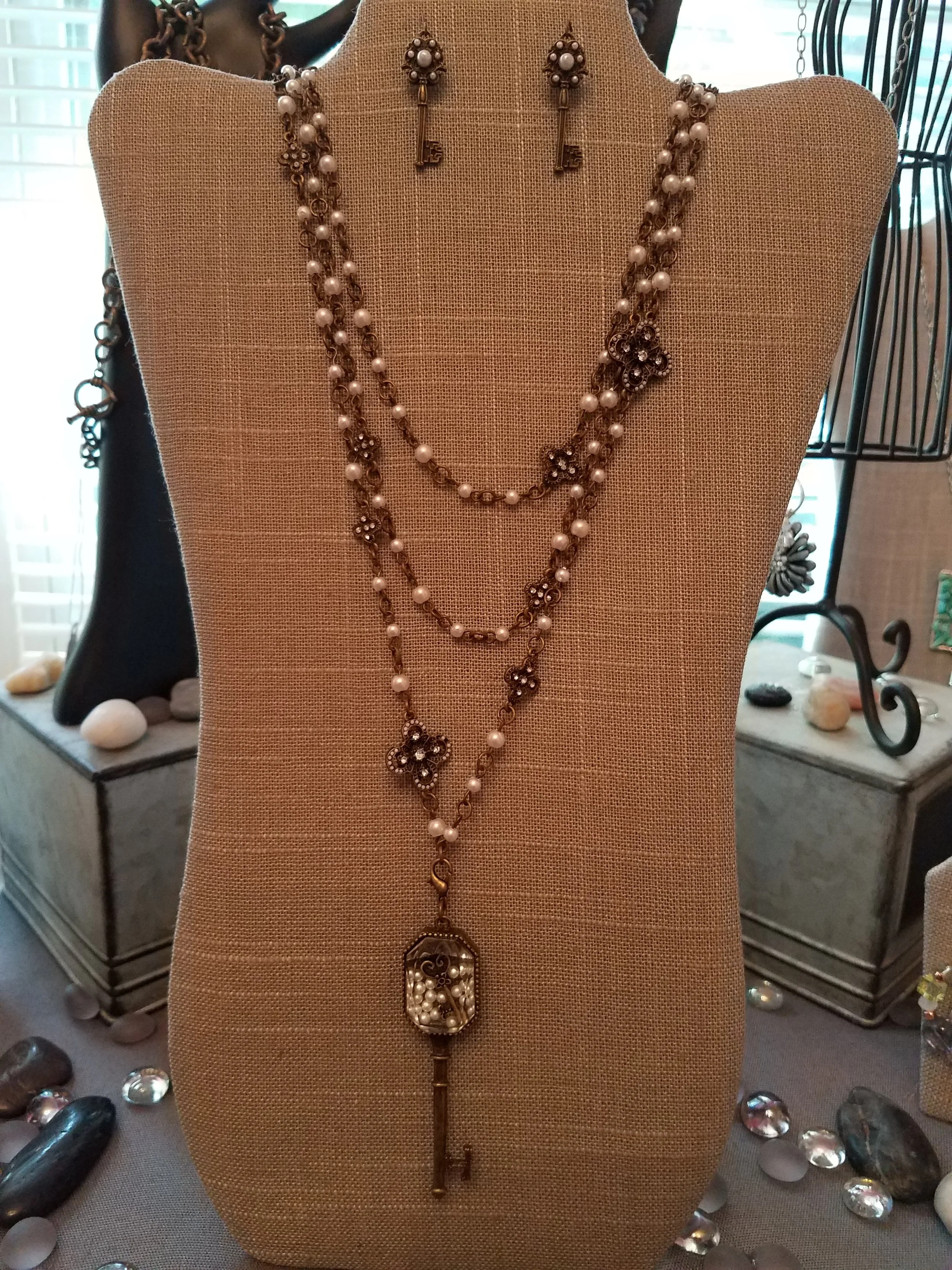 Antique gold triple chain with white pearls. Key has pearls inside the glass. Matching key earrings. 18-24”