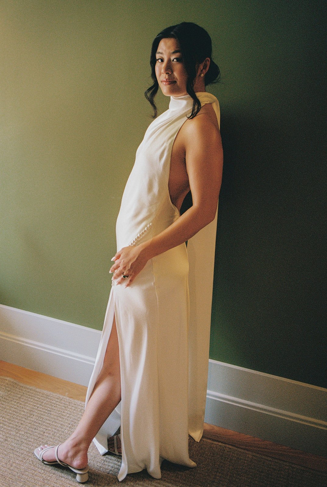 Bride in Saulee high-neck gown against green wall, film wedding photography northern Portugal — The Lopes Photography