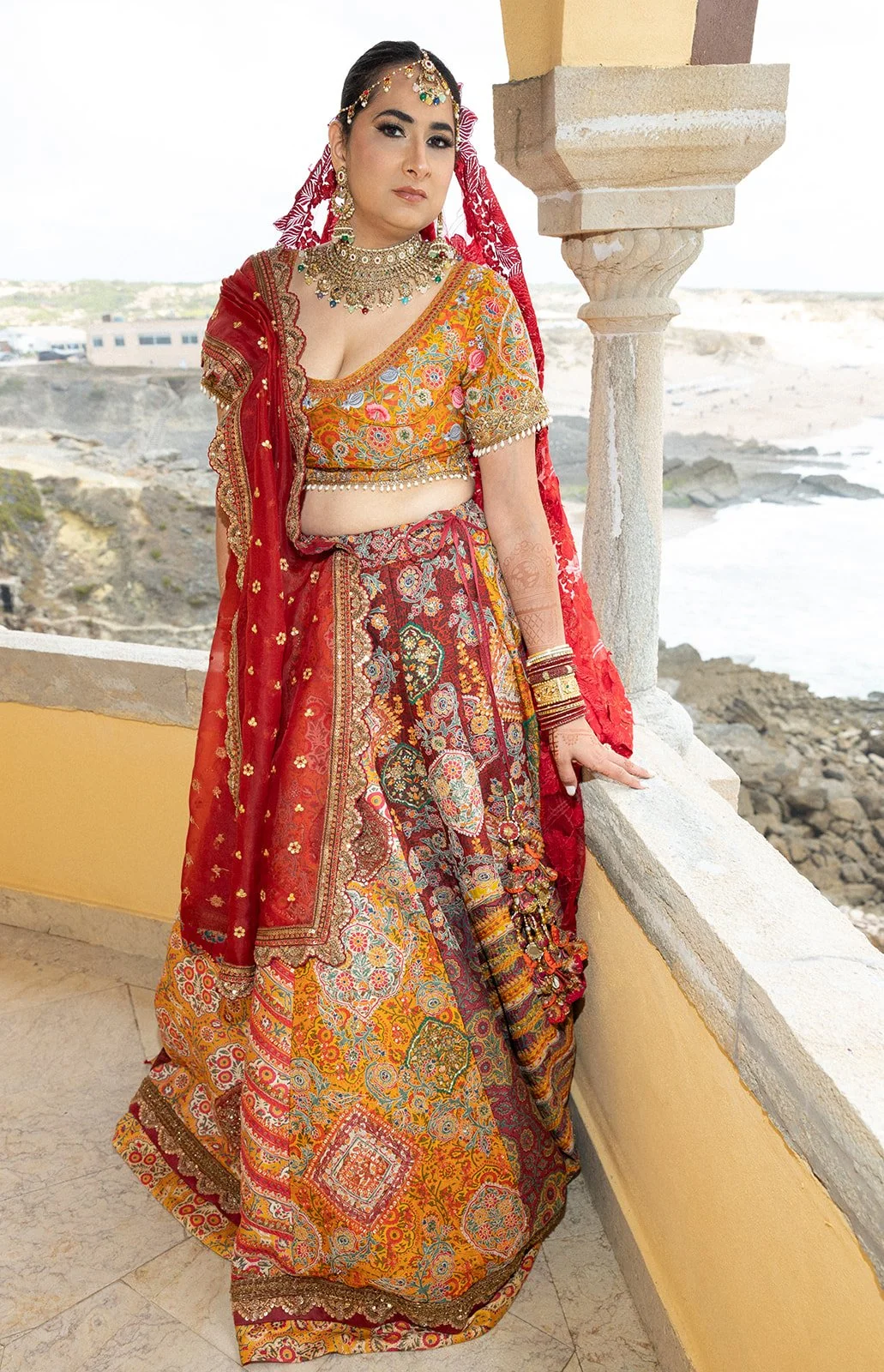 ndian bride in red lehenga on Atlantic balcony, Fortaleza do Guincho, by The Lopes Photography