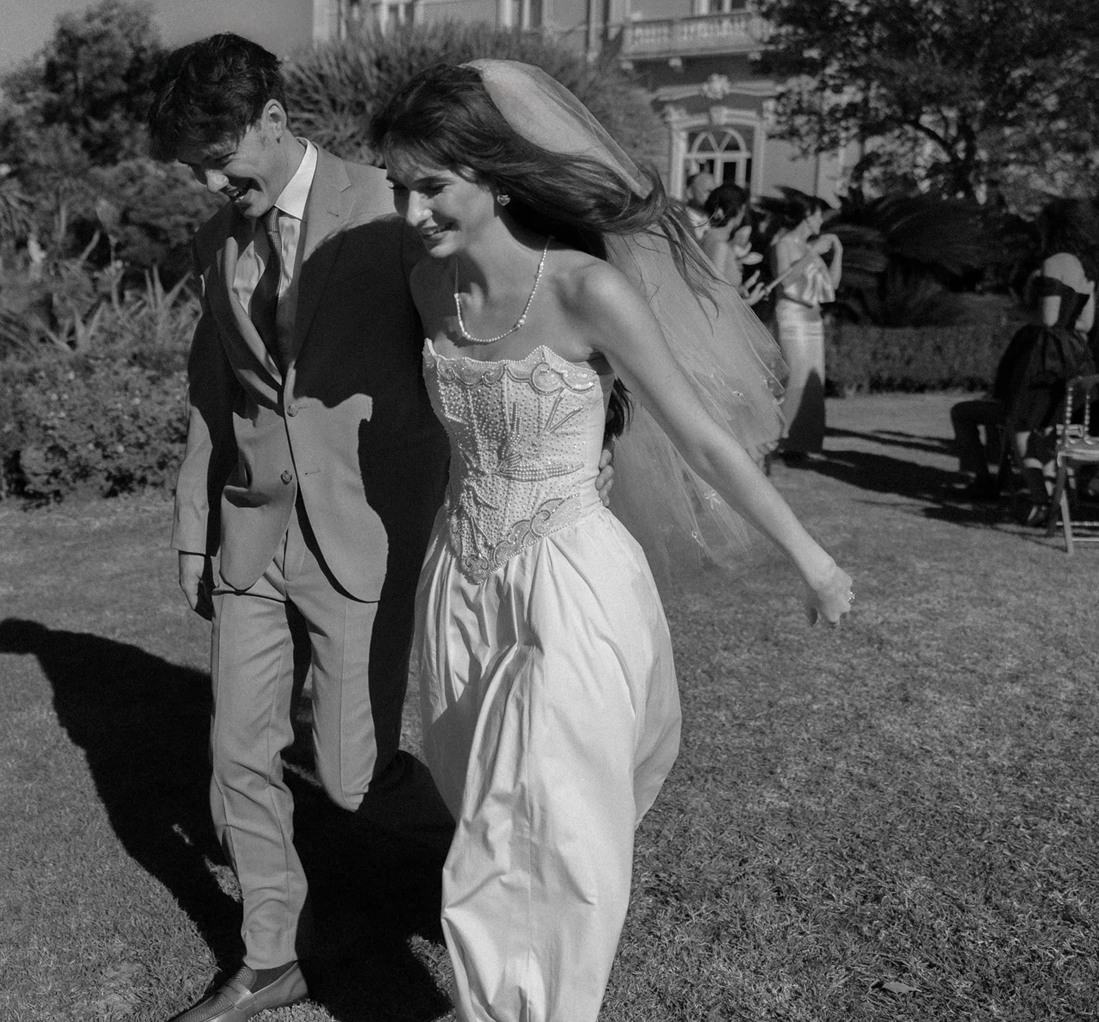 Black and white photo of a couple walking away from the ceremony location