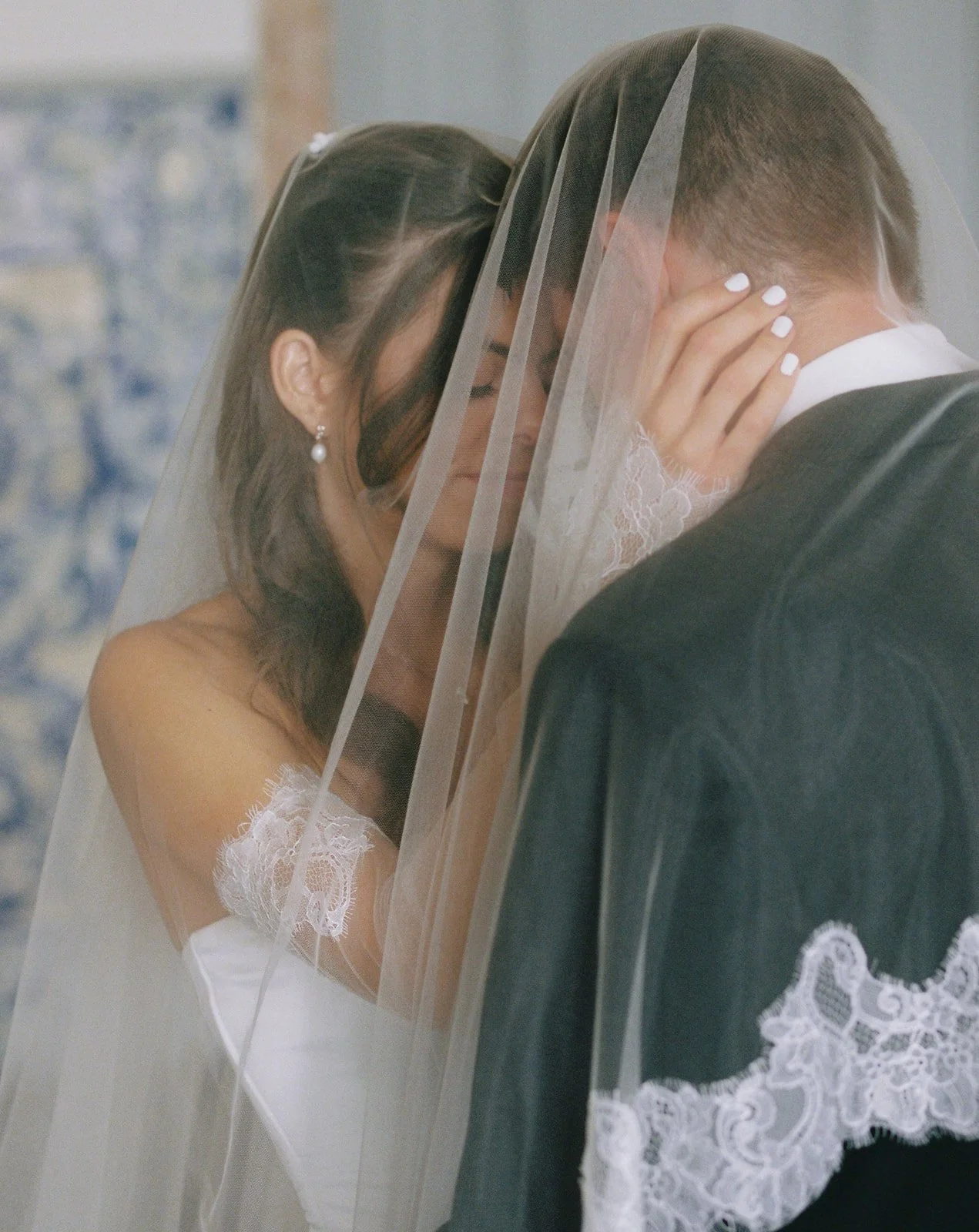 Bride and groom under the veil with foreheads touching.jpg