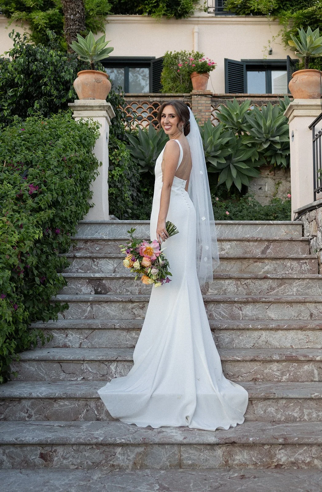 Bride on stone steps looking over her shoulder, Belmond Grand Hotel Timeo, wedding photography by The Lopes Photography