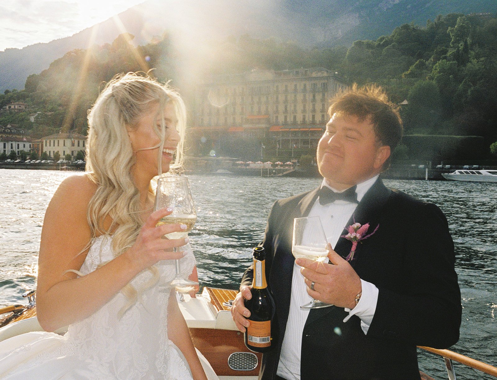Couple toasting champagne aboard a speedboat on Lake Como at golden hour, Italy, destination wedding photography — The Lopes Photography