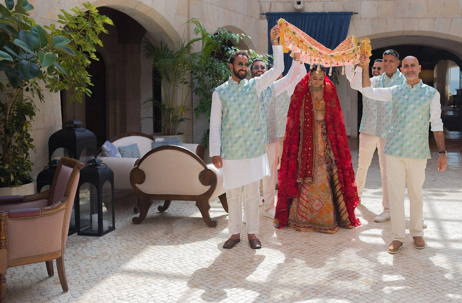Candid garland moment in stone courtyard, Indian destination wedding Fortaleza do Guincho | The Lopes Photography*