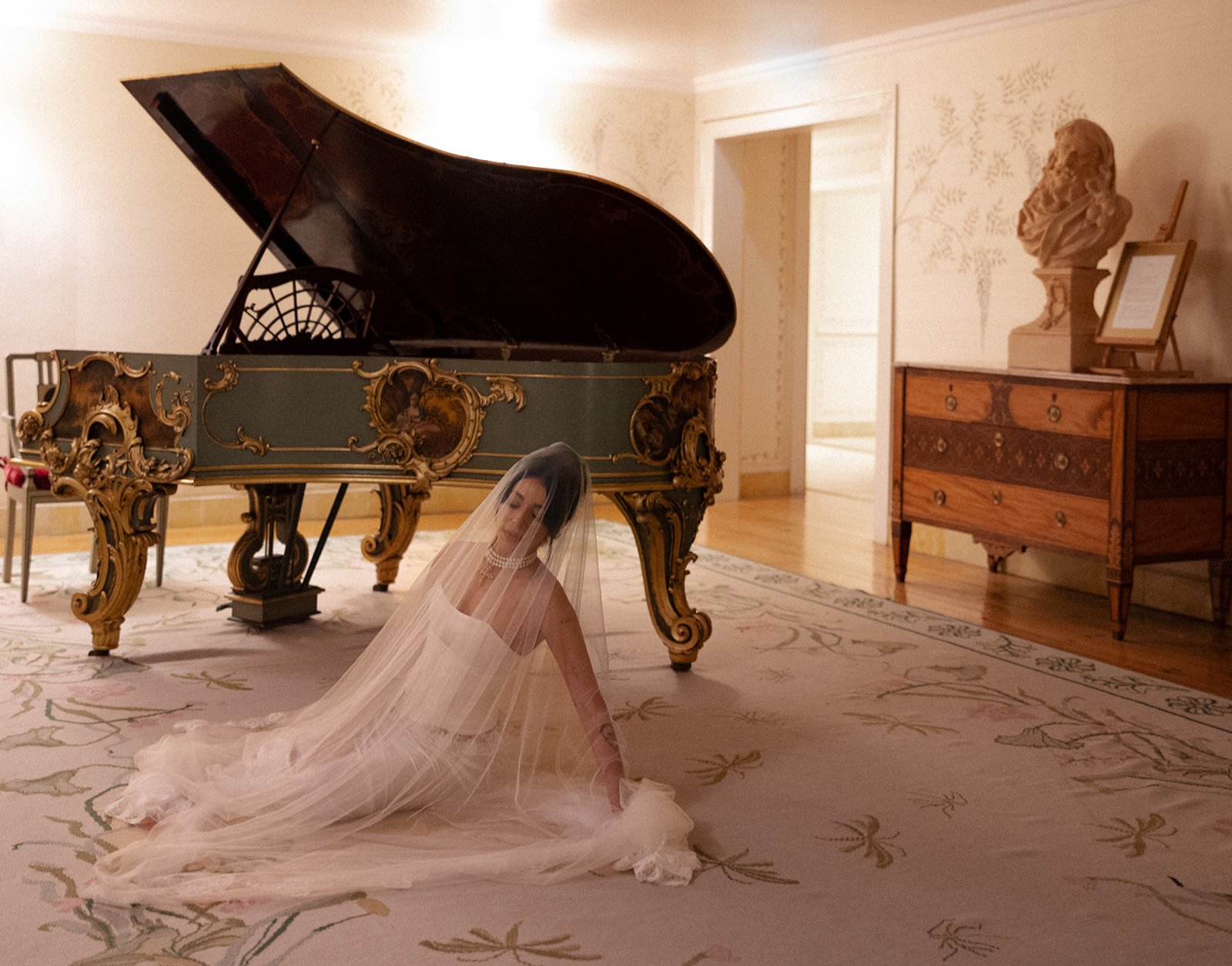 Bride kneeling on an ornate patterned rug with her cathedral veil spread in a full arc, gilded Baroque salon at Palácio de Seteais, Sintra elopement | The Lopes Photography