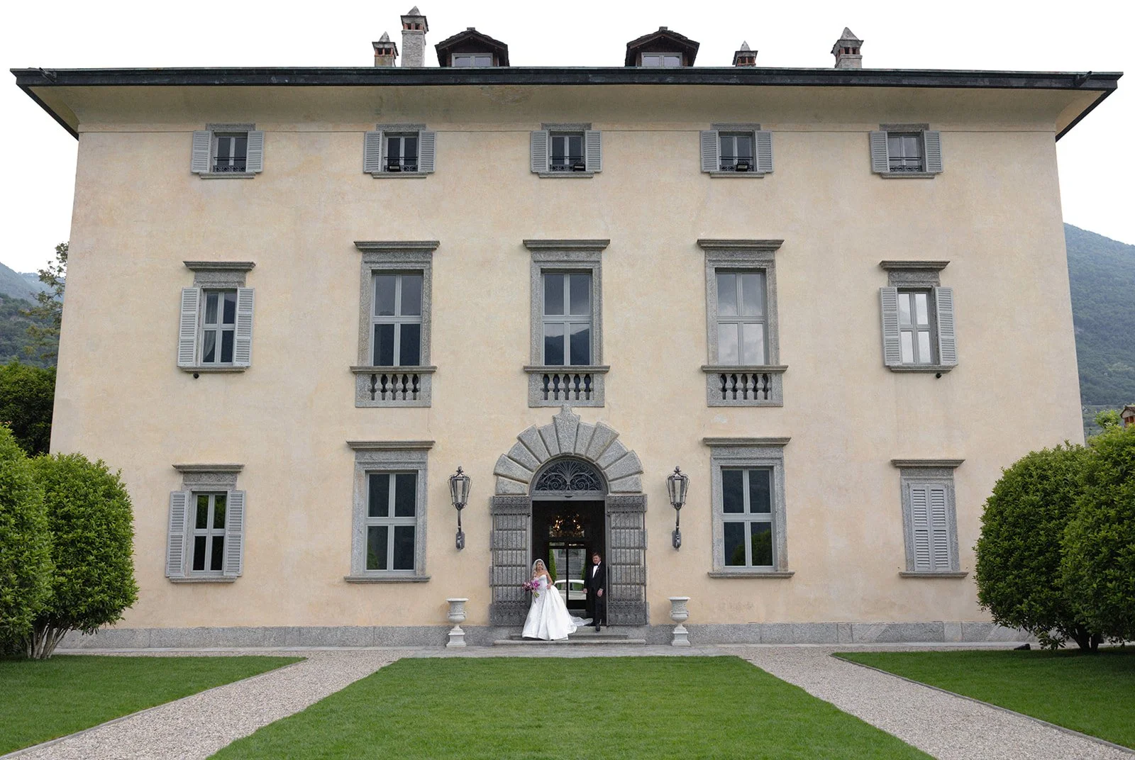 Couple standing at the entrance of Villa Balbiano's neoclassical facade above Lake Como, Italy, destination wedding photography — The Lopes Photography