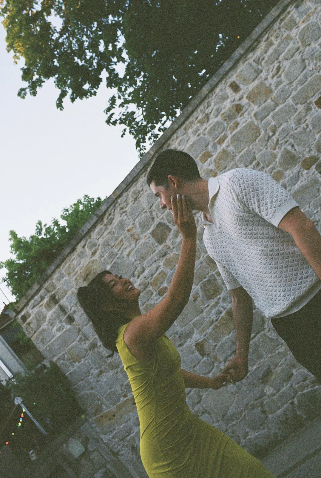 Couple against a Porto stone wall with film-grain texture, destination wedding portrait by The Lopes Photography