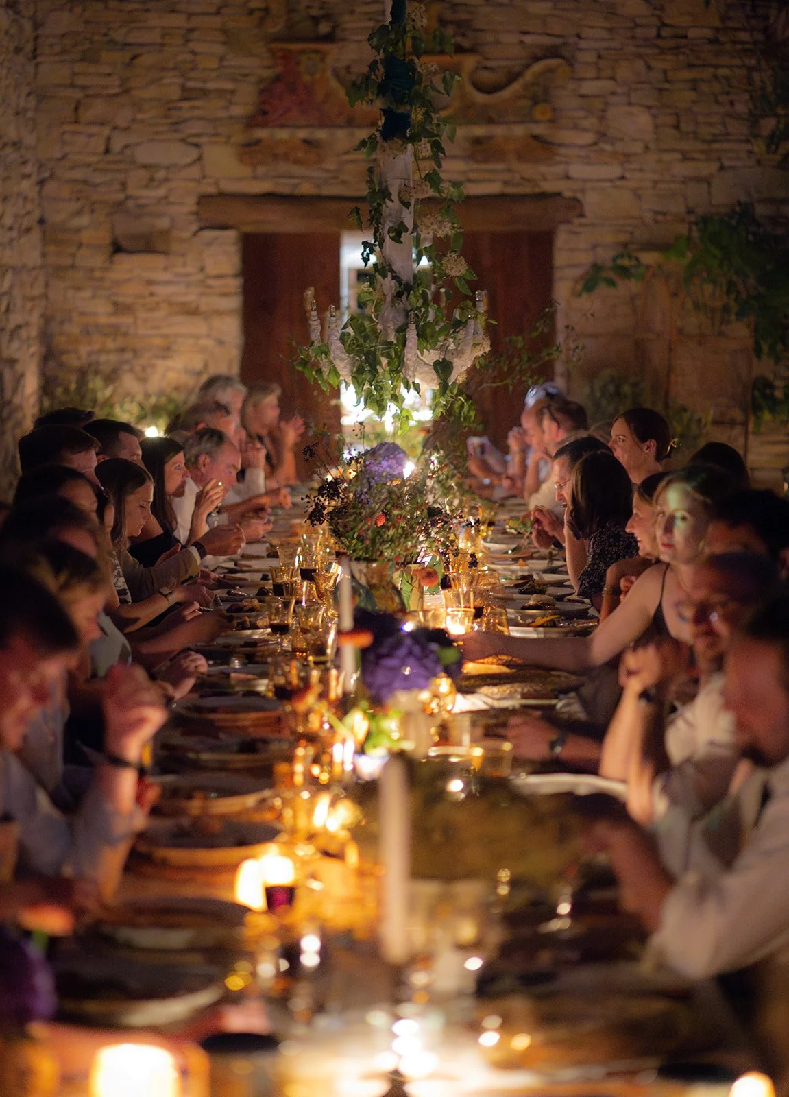 Wedding reception dinner at night at Le Grand Banc, Provence, with a floral installation and candlelight | The Lopes Photography