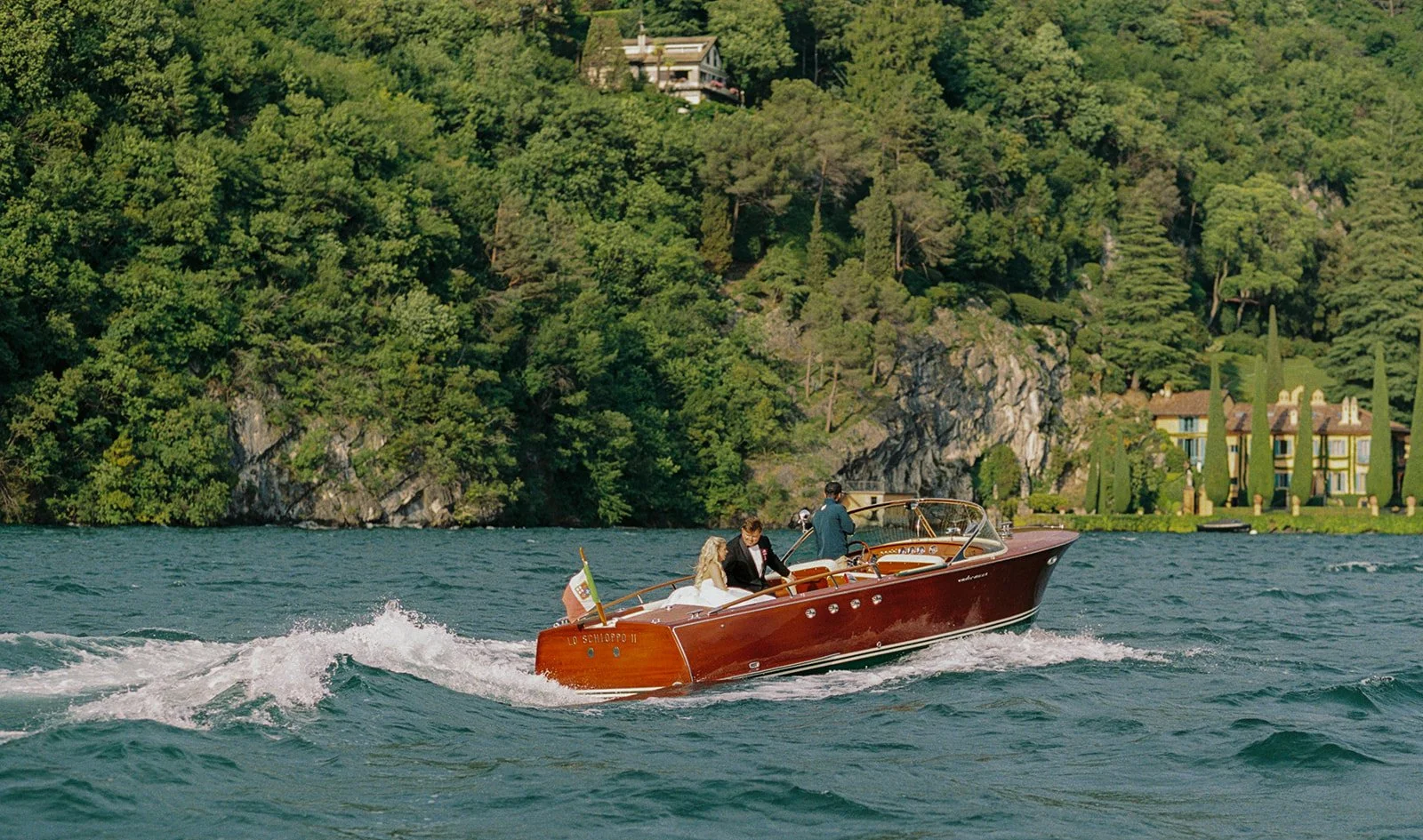Couple aboard a classic wooden speedboat crossing Lake Como, Italy, destination wedding photography — The Lopes Photography