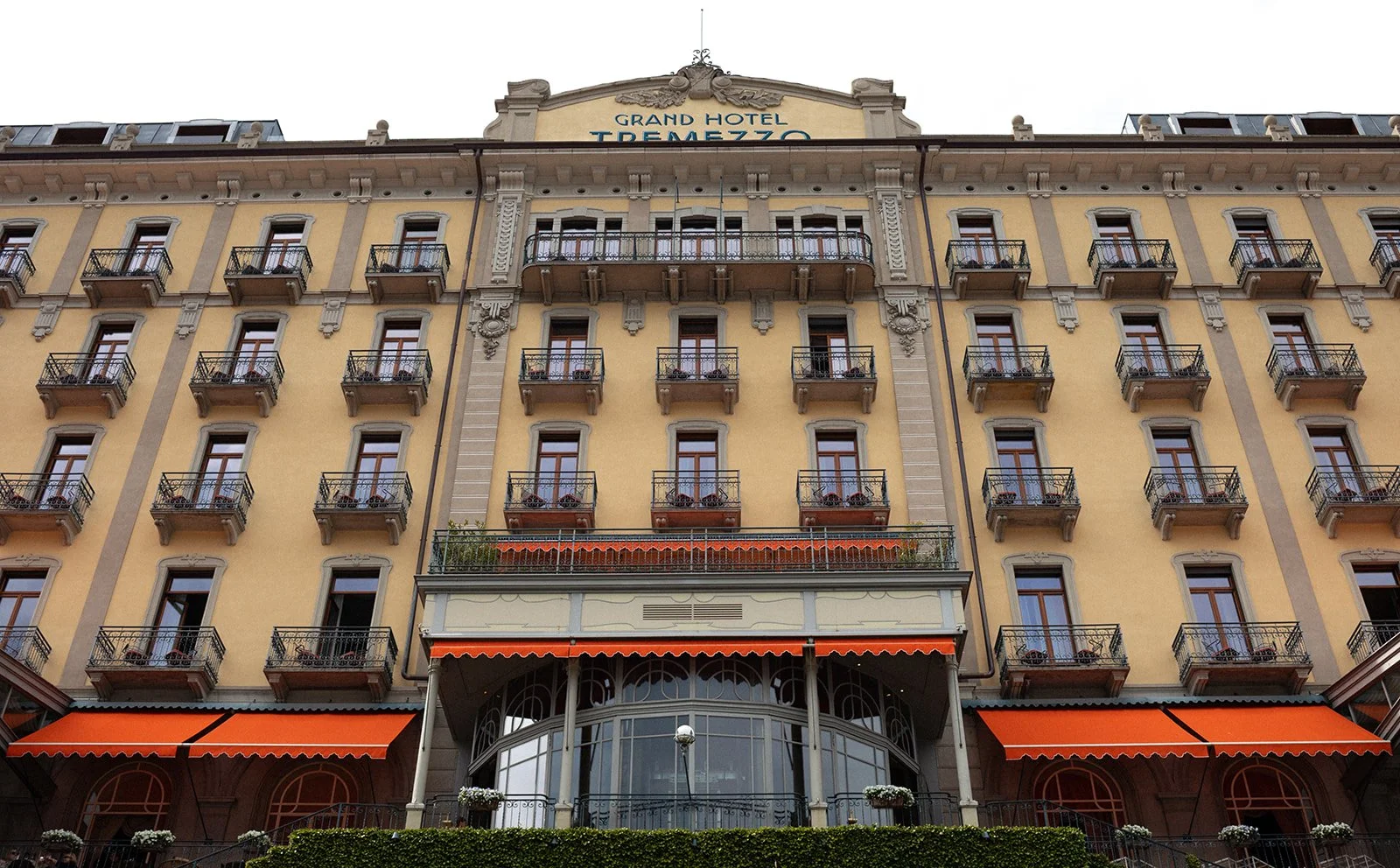 Exterior facade of Grand Hotel Tremezzo with orange and white striped awnings, Lake Como, Italy, destination wedding photography — The Lopes Photography