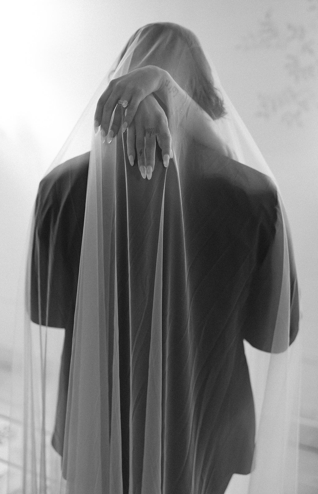 black and white photo of a bride and groom embracing each other