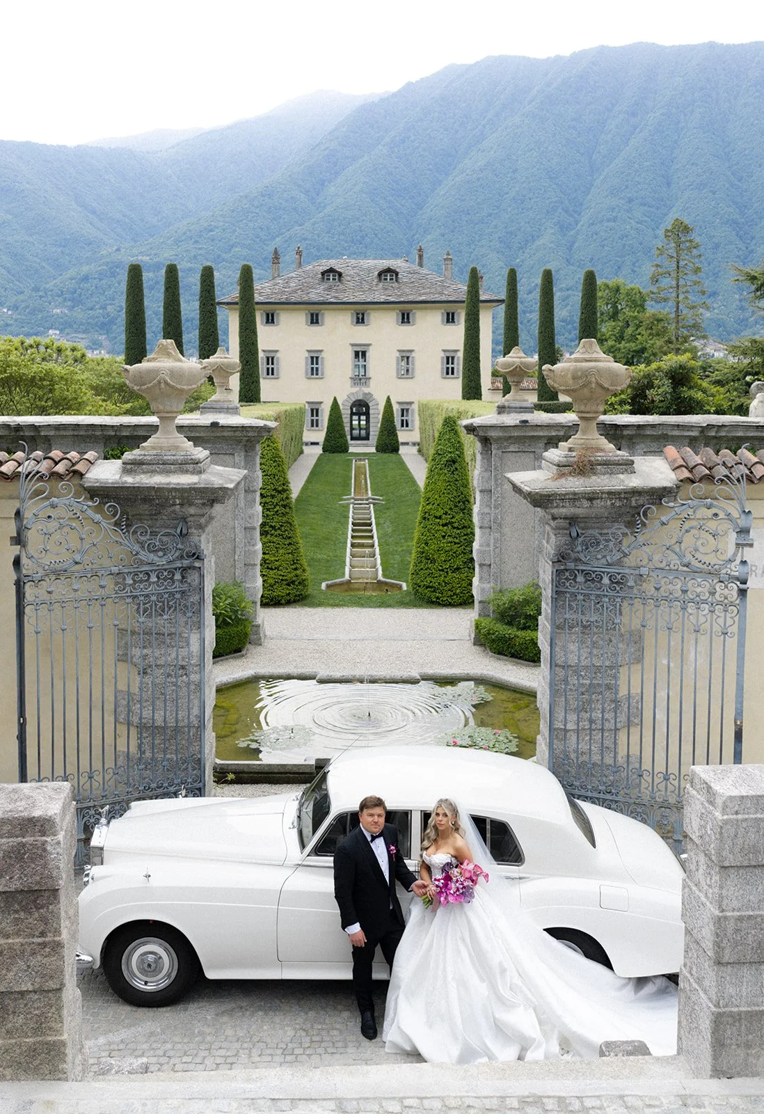 Couple exiting a vintage Rolls-Royce at the gates of Villa Balbiano, Lake Como, Italy, destination wedding photography — The Lopes Photography