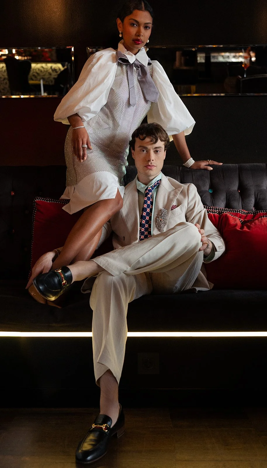 Couple posed on a dark velvet banquette, cream suit and white dress, fashion editorial at 138 Liberdade, Lisbon — The Lopes Photography