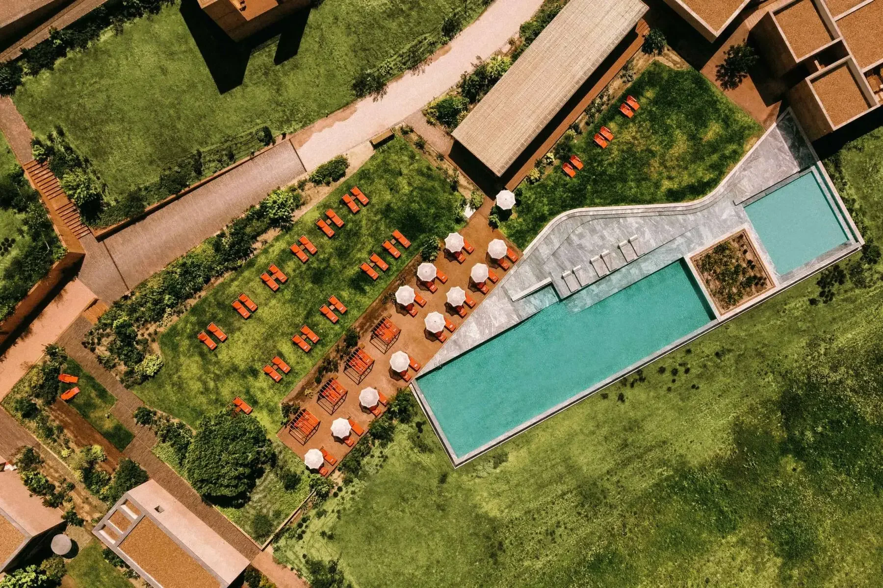 Aerial view of the pool and lawn terraces at Praia do Canal Nature Retreat in Aljezur, Algarve, a modern minimalist wedding venue in Portugal.