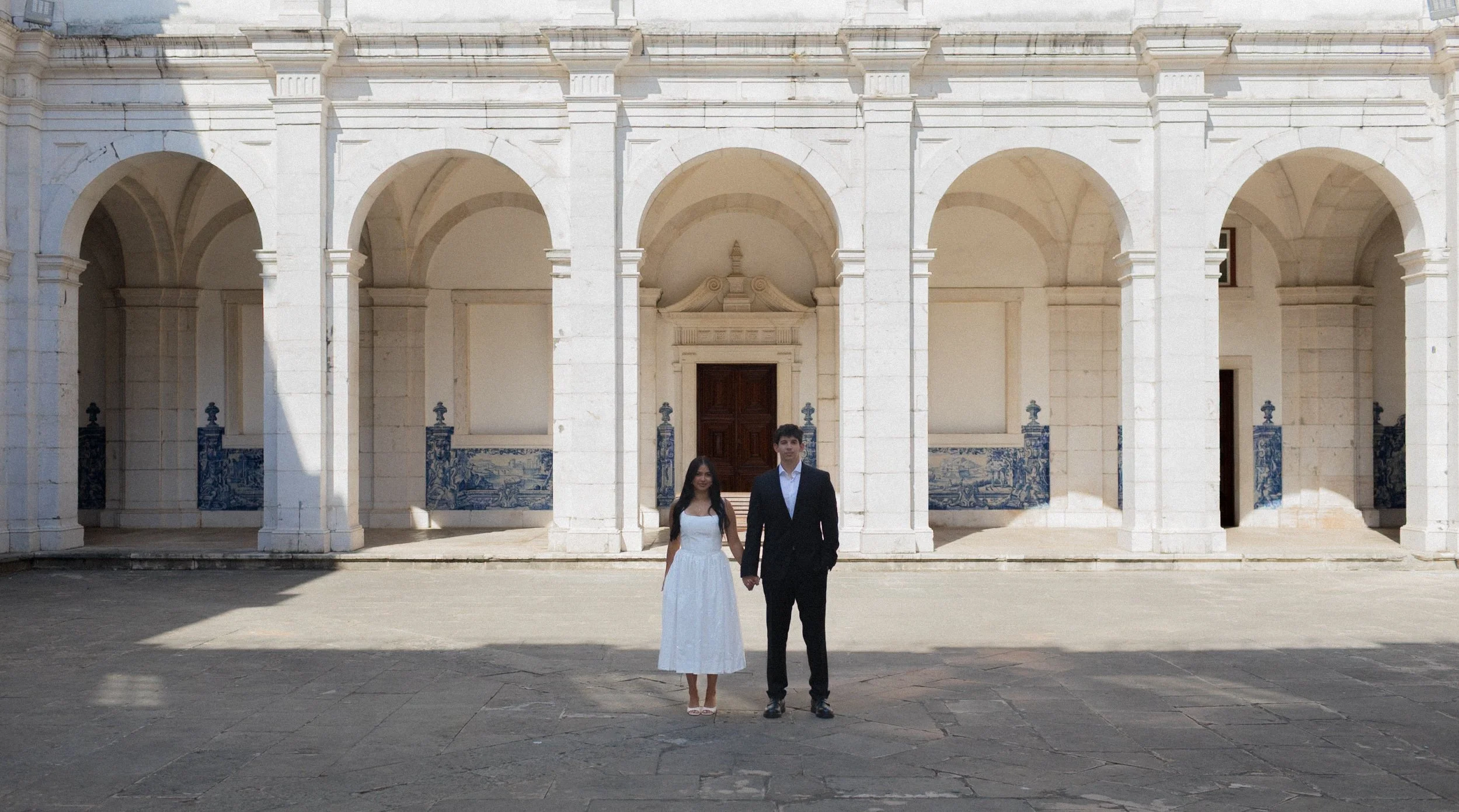 Editorial wedding portrait of a couple framed by Portuguese architecture