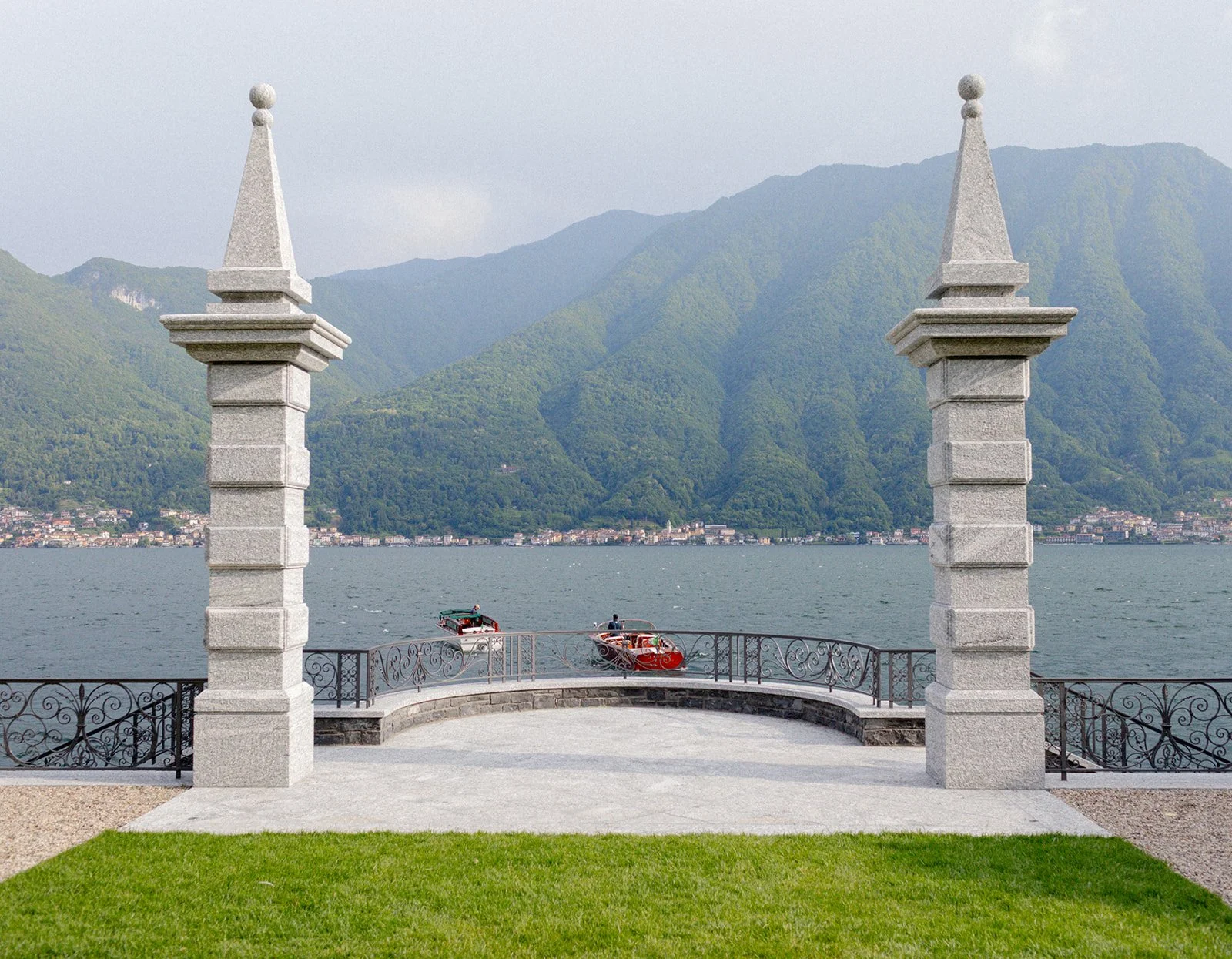 Symmetrical view of Villa Balbiano's lakeside terrace framed by stone pillars overlooking Lake Como, Italy, destination wedding photography — The Lopes Photography