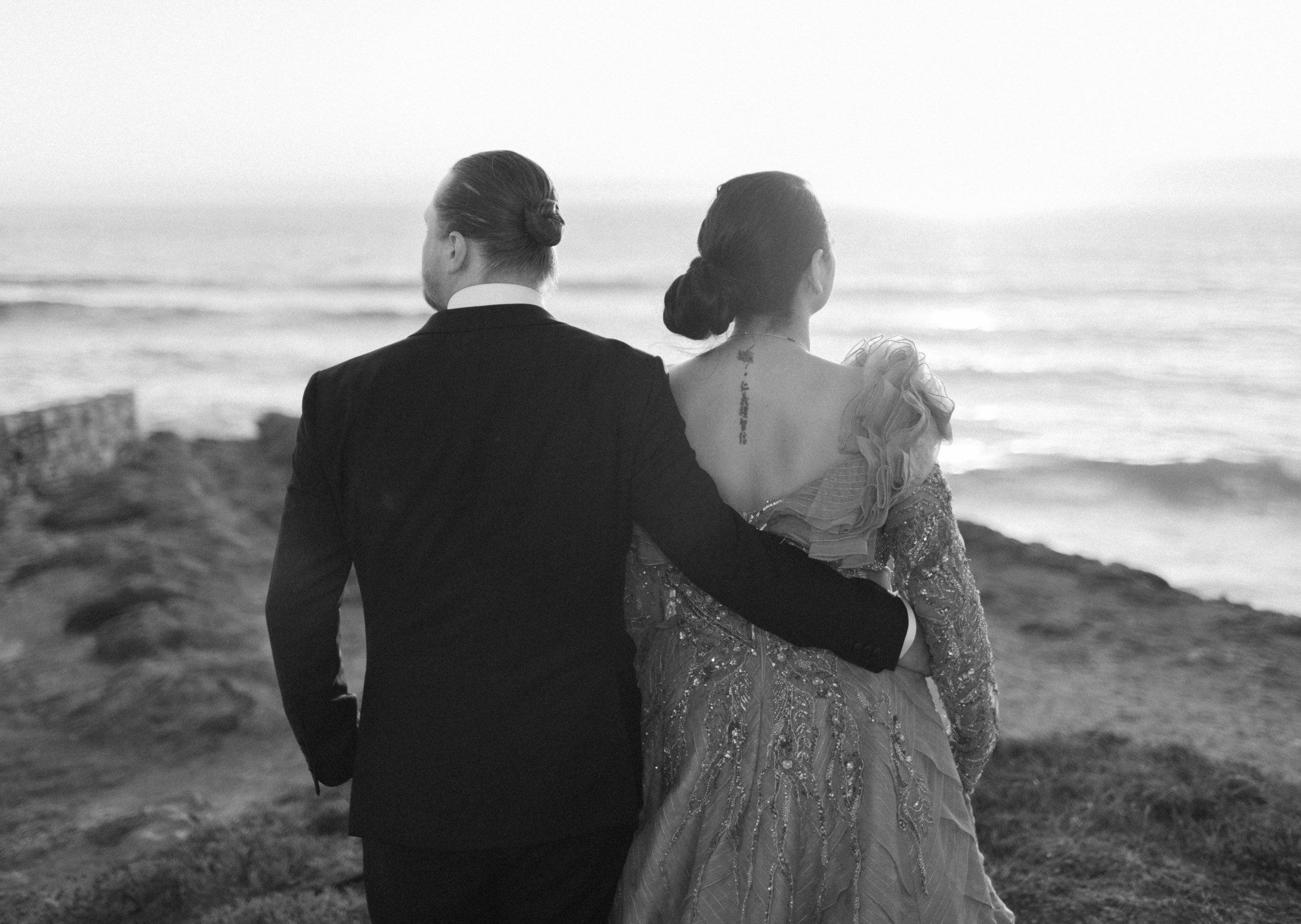 Destination wedding couple walking together by the ocean in Portugal, photographed in an editorial black and white style