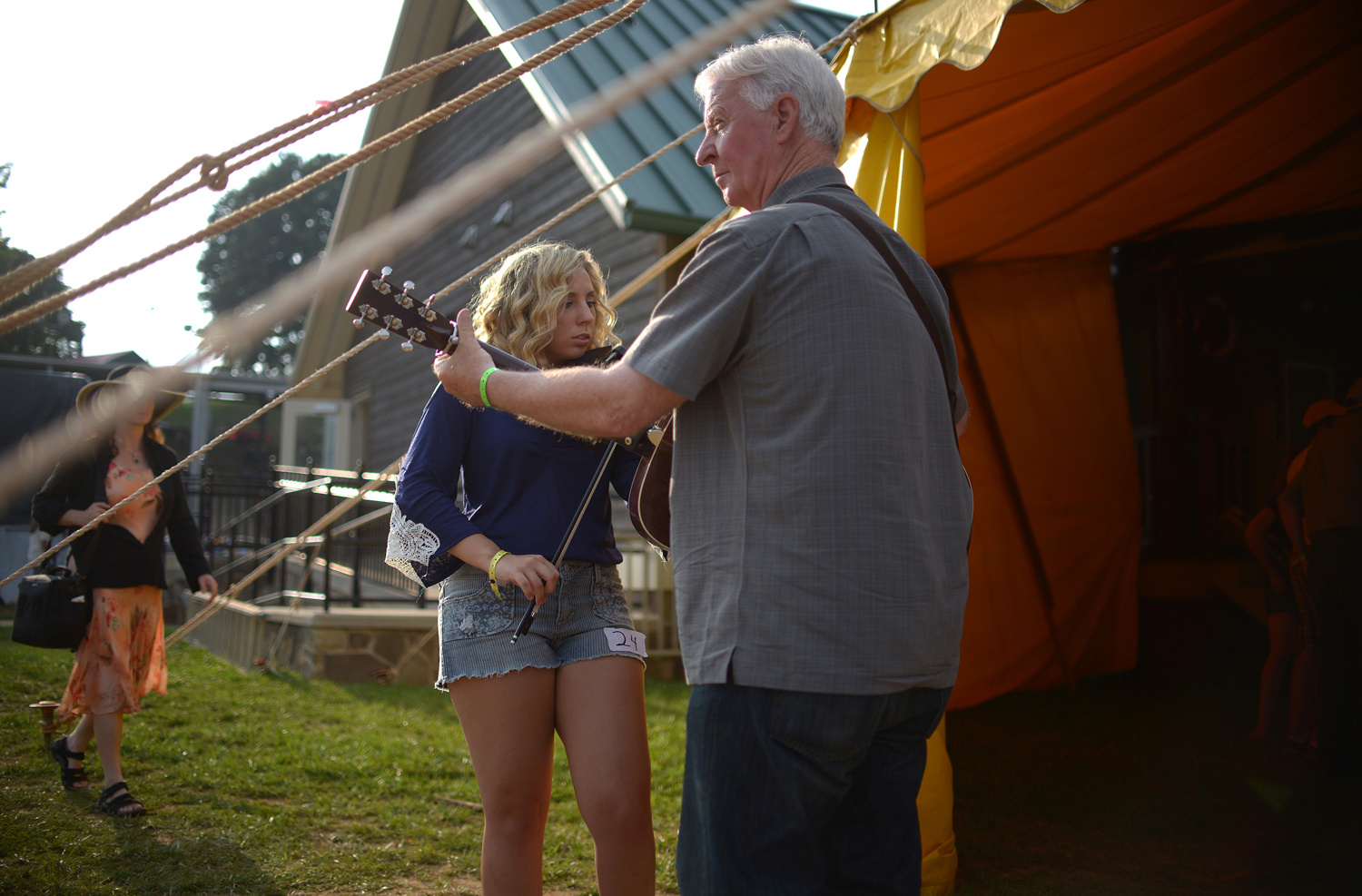 Pat Jarrett / The Virginia Folklife Program . August 6, 2014. Katie Griffin of Eden, North Carolina warms up with Johnny Williams of Danville during the fiddle contest. Thousands came to Felt's Park for the 79th Galax Old Fiddlers' Convention. Galax, Virginia.