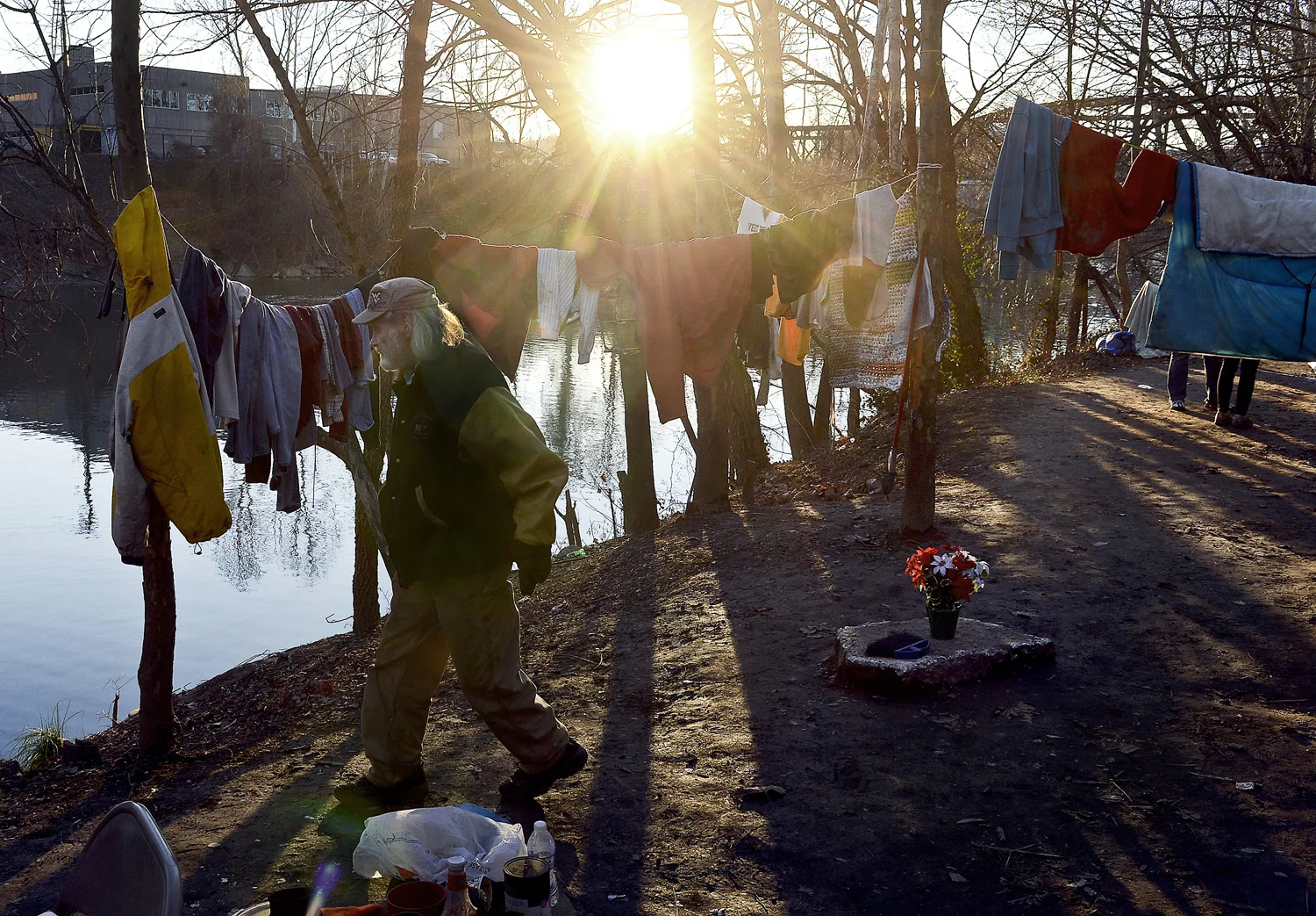 F. Brian Ferguson. January 2, 2015. James "Ace" Everett, 72, walks among the tents and clotheslines that is known as Tent City near the Spring Street Bridge. Everett claims to have been the first resident of Tent City after he cleared the area along the banks of the Elk River. He has currently found an indoor residence but still comes to the river bank to visit his friends. Charleston, Kanawha County, West Virginia.
