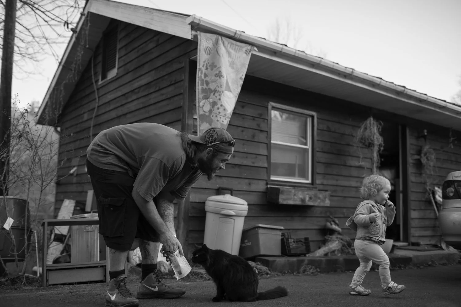 Chris Jackson . March 31, 2014. Chris Smith entertains a cat with yogurt treats as his daughter, Lilly, 16-months, wonders off at a home in Shepherdstown, Jefferson County, West Virginia.