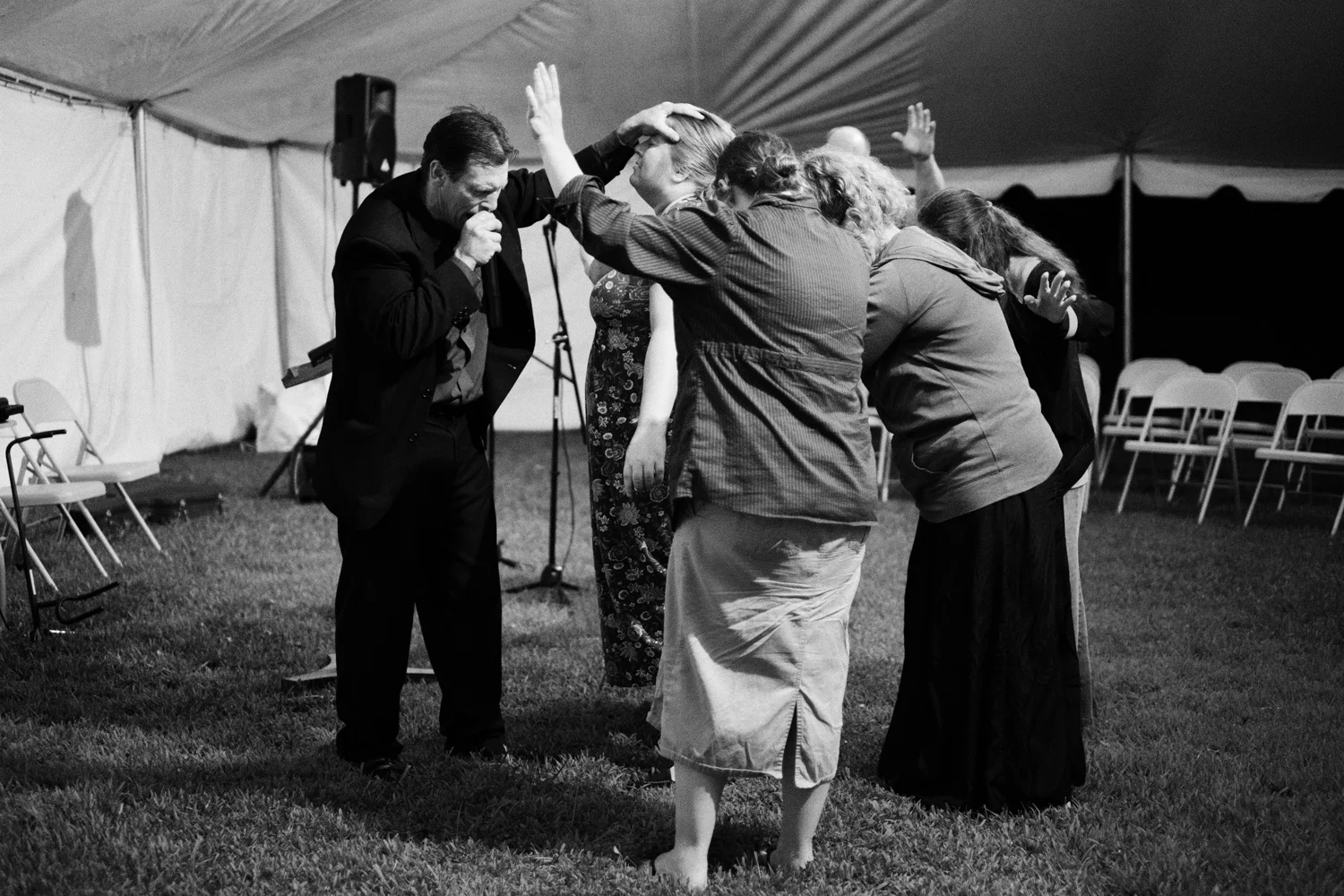 Roger May . August 2, 2014. Preacher Roger Stevens prays for a woman at a tent revival in Baisden, Mingo County, West Virginia.