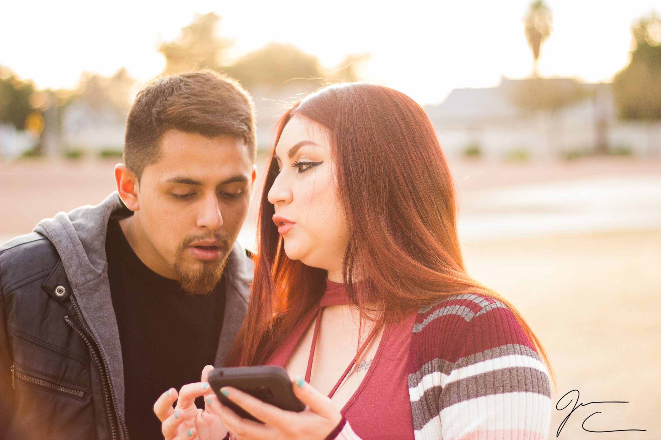 Candid outdoor portrait of a couple looking at a phone together, portrait photography by Everlux Photo Co.