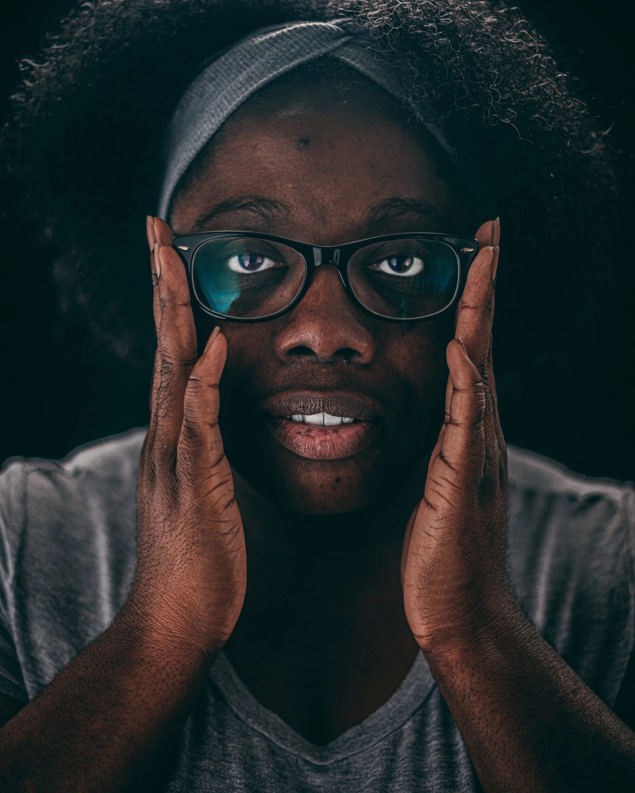 Emotive studio portrait of a man with hands framing his face, portrait photography by Everlux Photo Co.