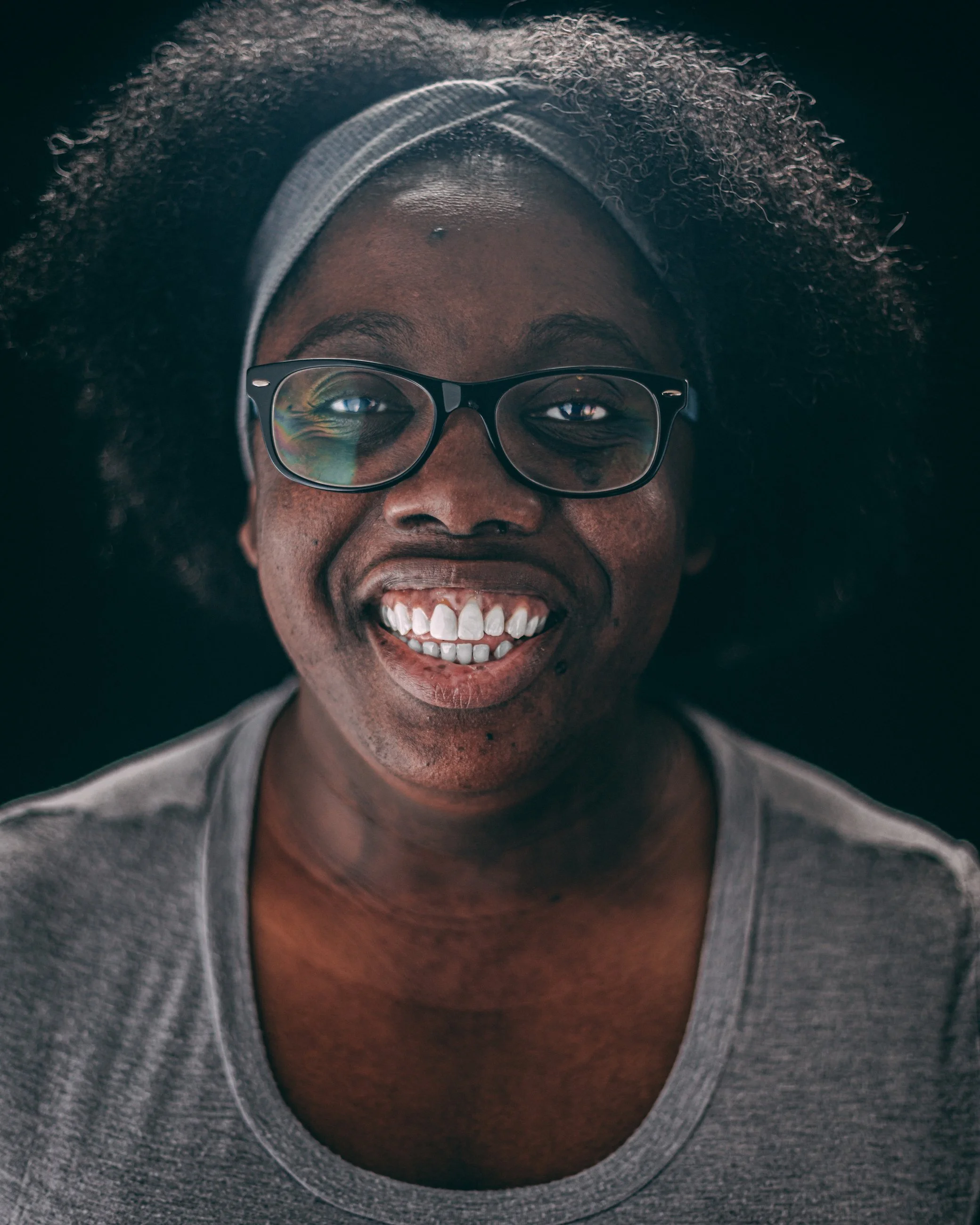 Studio portrait of a smiling woman with glasses and a headband, portrait photography by Everlux Photo Co.