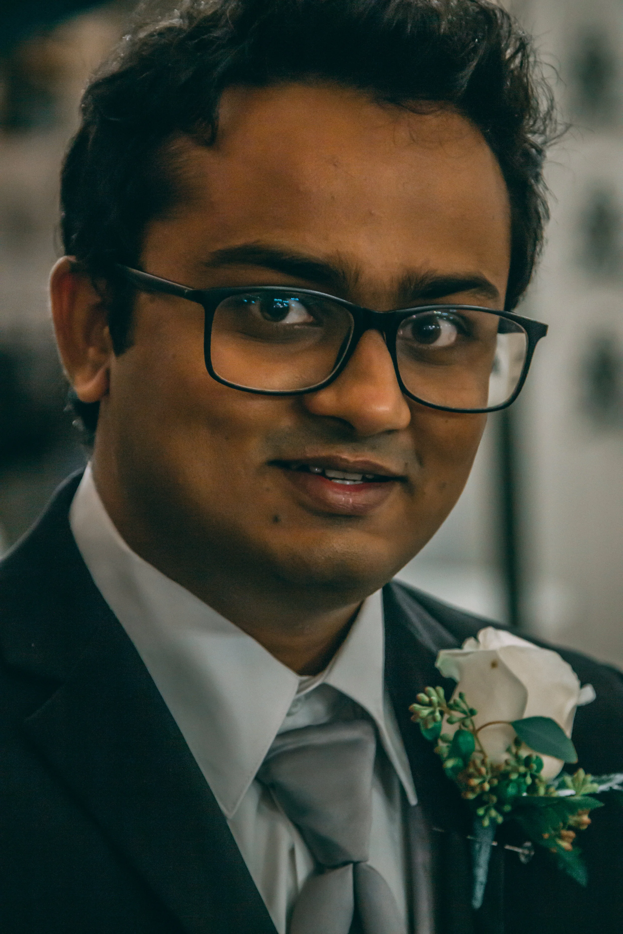 Portrait of a man in glasses wearing a boutonniere at a wedding event, wedding photography by Everlux Photo Co.