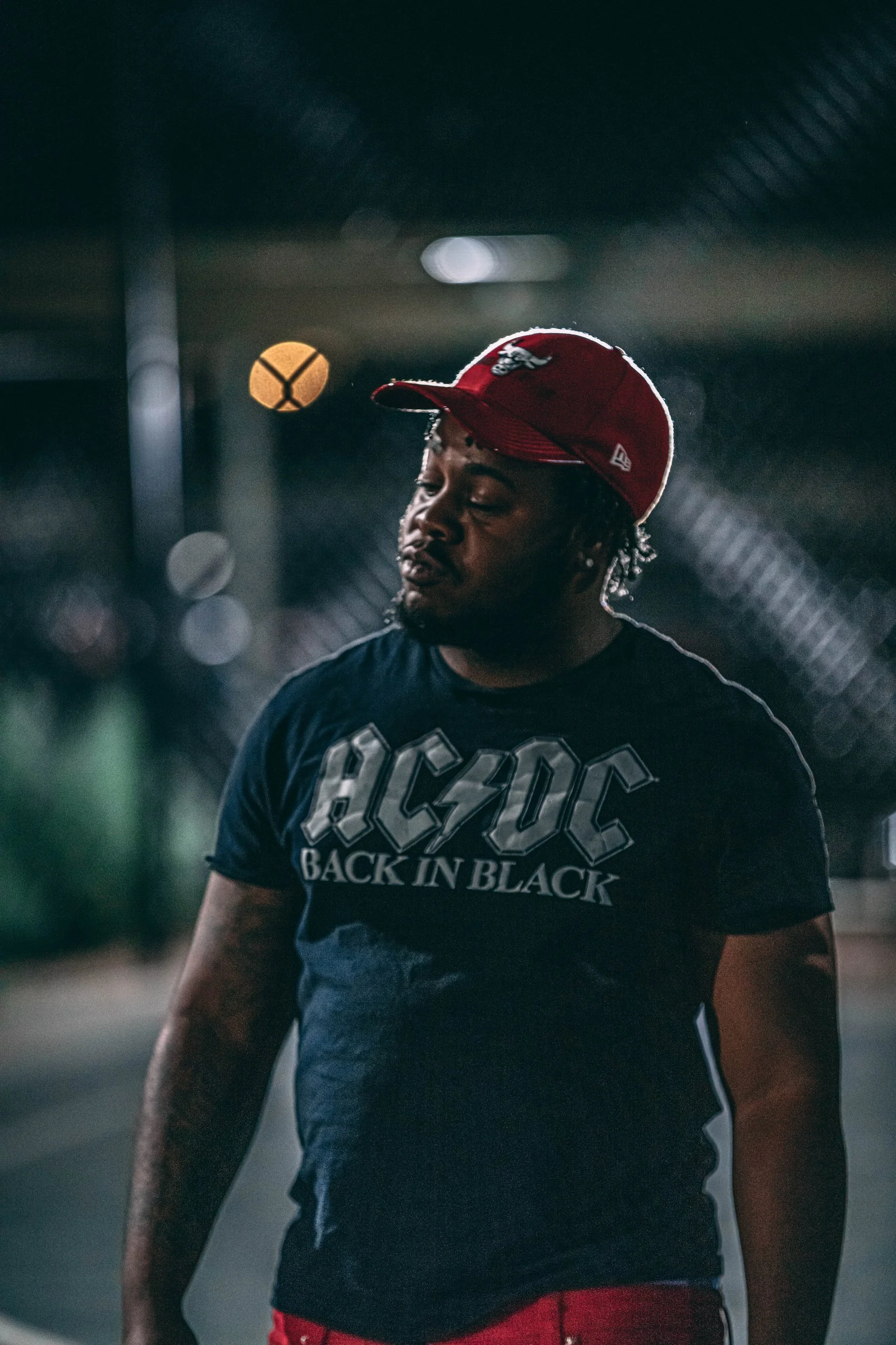 Portrait of a man in a red cap and graphic t-shirt in an urban setting, portrait photography by Everlux Photo Co.