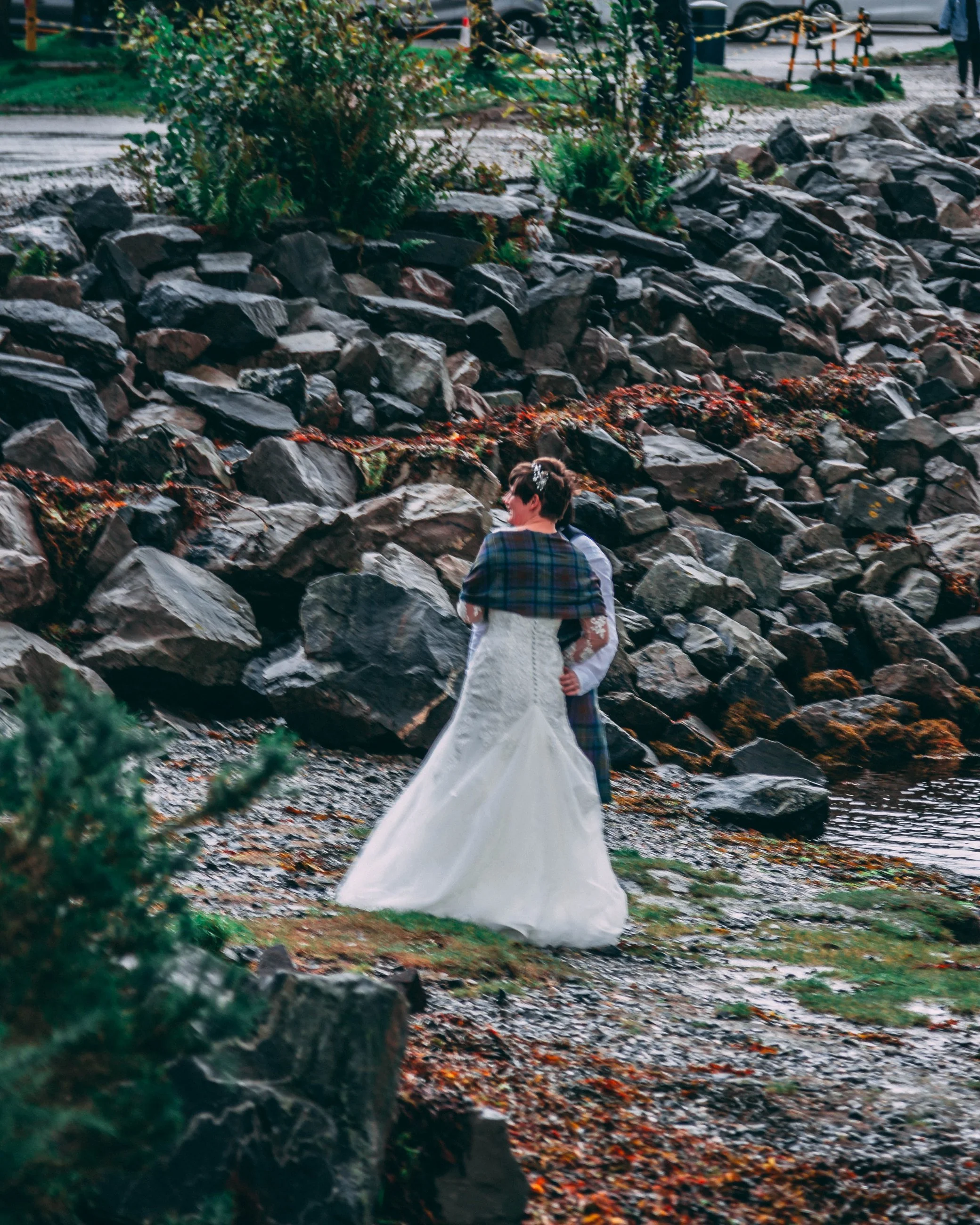 Portrait of a woman in a white gown walking along a rocky creek path, bridal portrait photography by Everlux Photo Co.