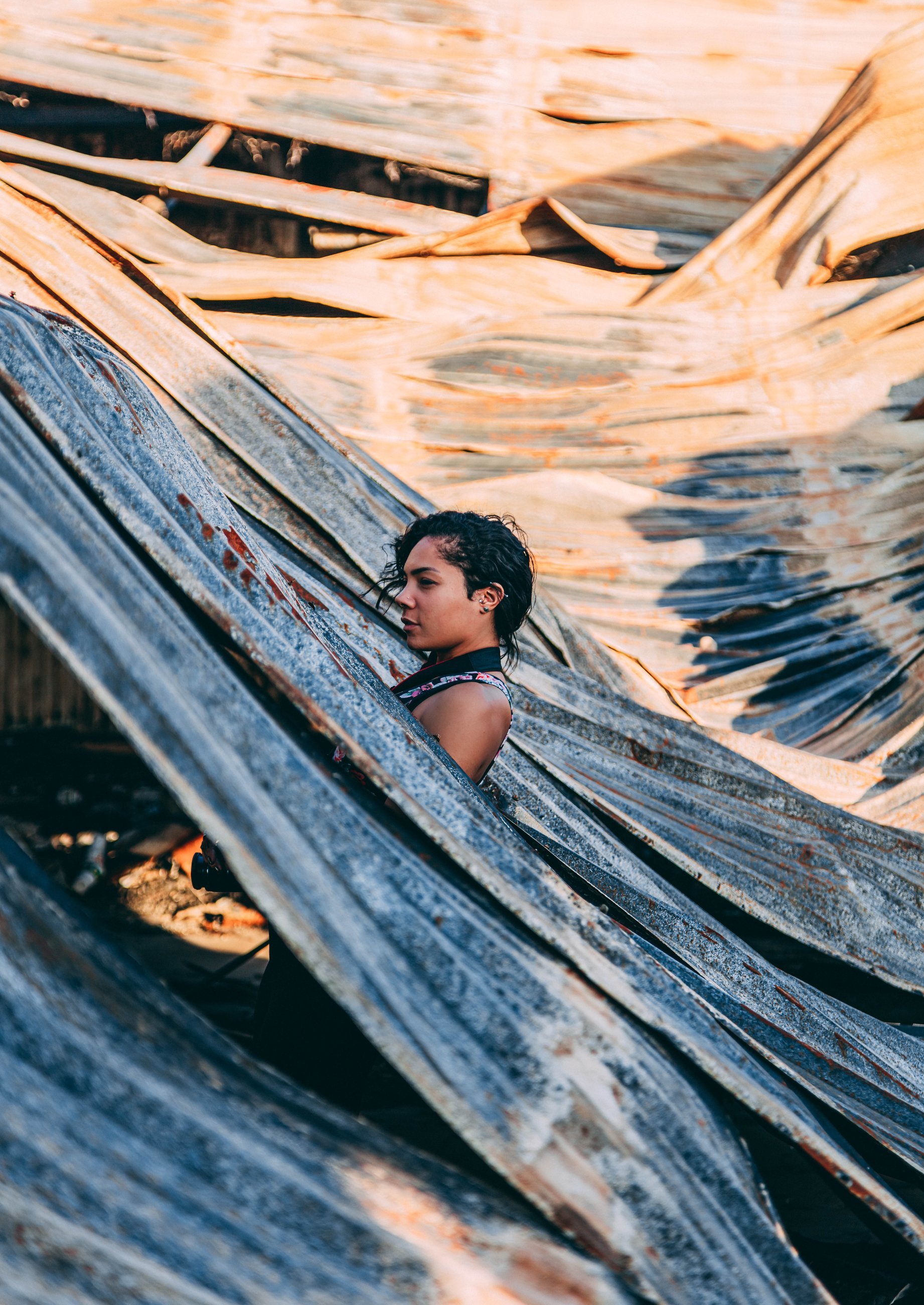 Creative portrait of a person against corrugated metal with warm golden light, portrait photography by Everlux Photo Co.